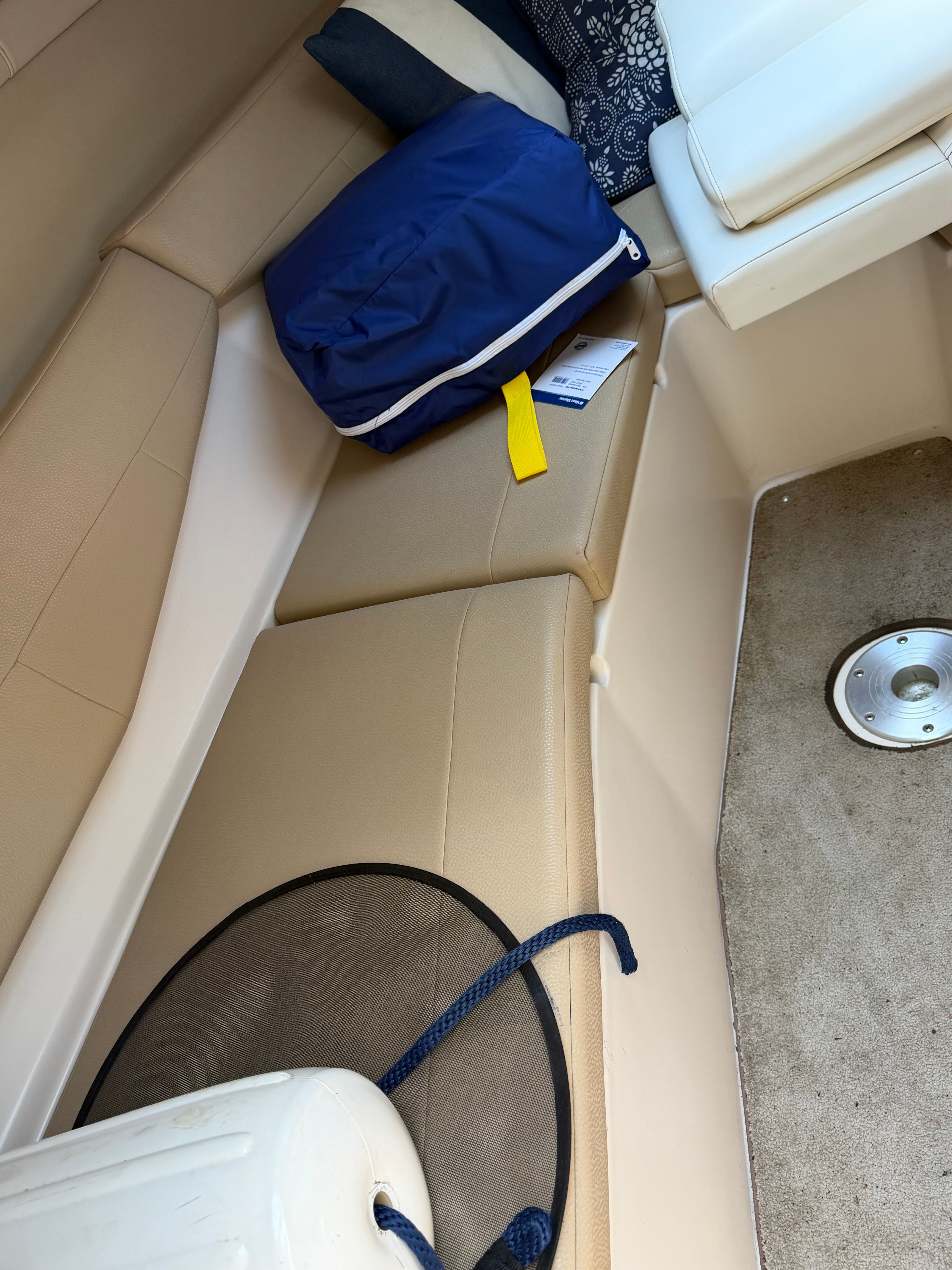 The image shows the interior of a 2011 Regal 2750 Cuddy with beige upholstery and blue cushions.