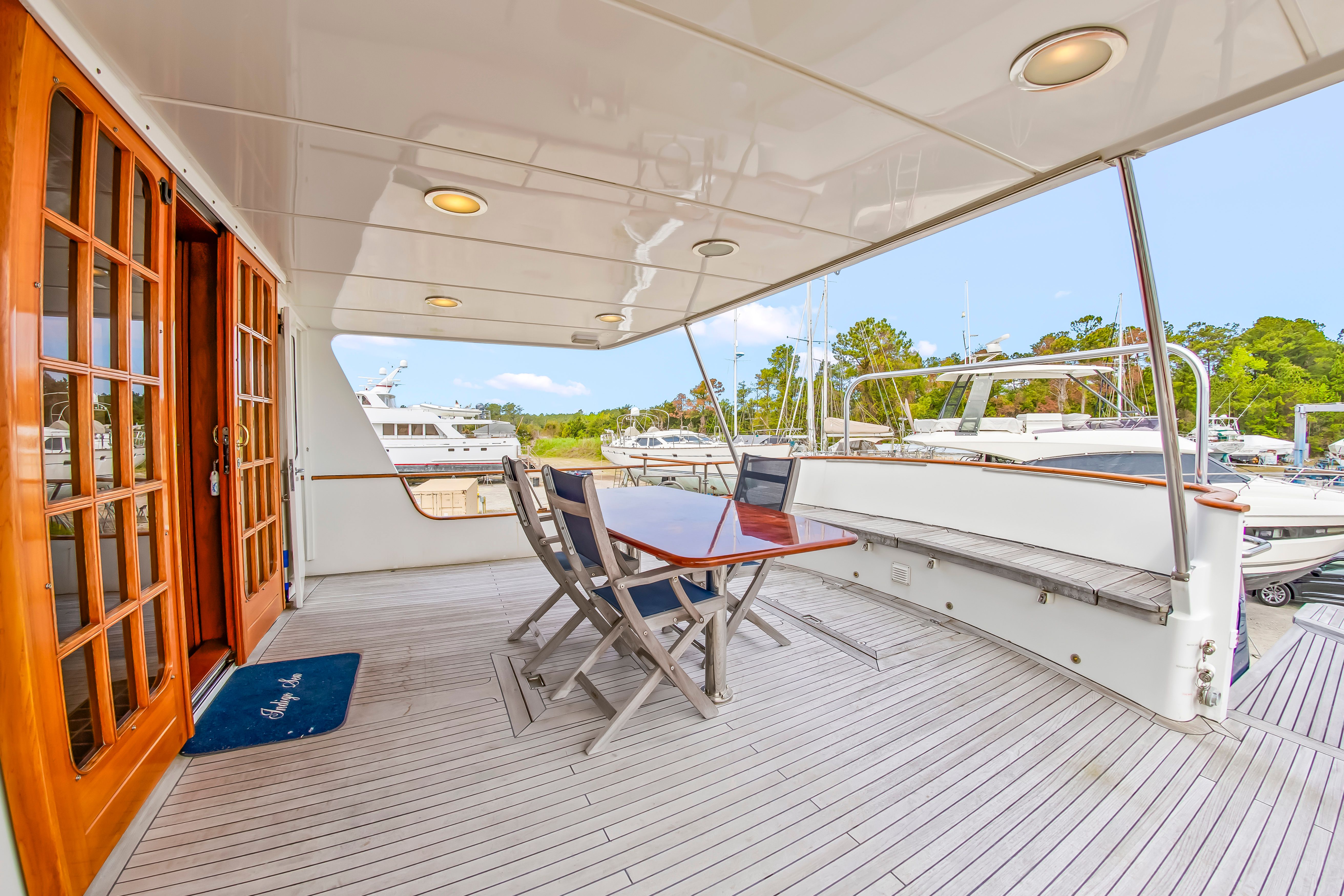 The image shows the deck of a 1987 Jongert 78 Motor Yacht with a table and chairs.