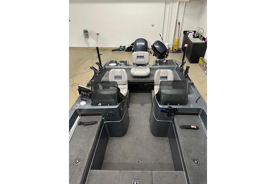 1999 Stratos 219 CF boat interior with seating and controls in a garage setting.