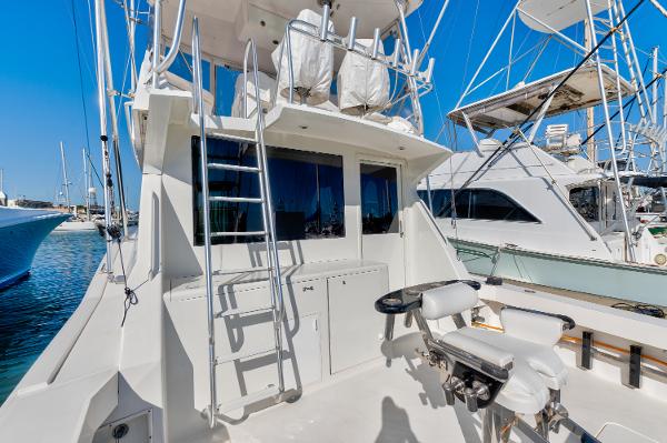 1999 Viking 47 Convertible yacht with fishing chair and ladder, docked in a marina.