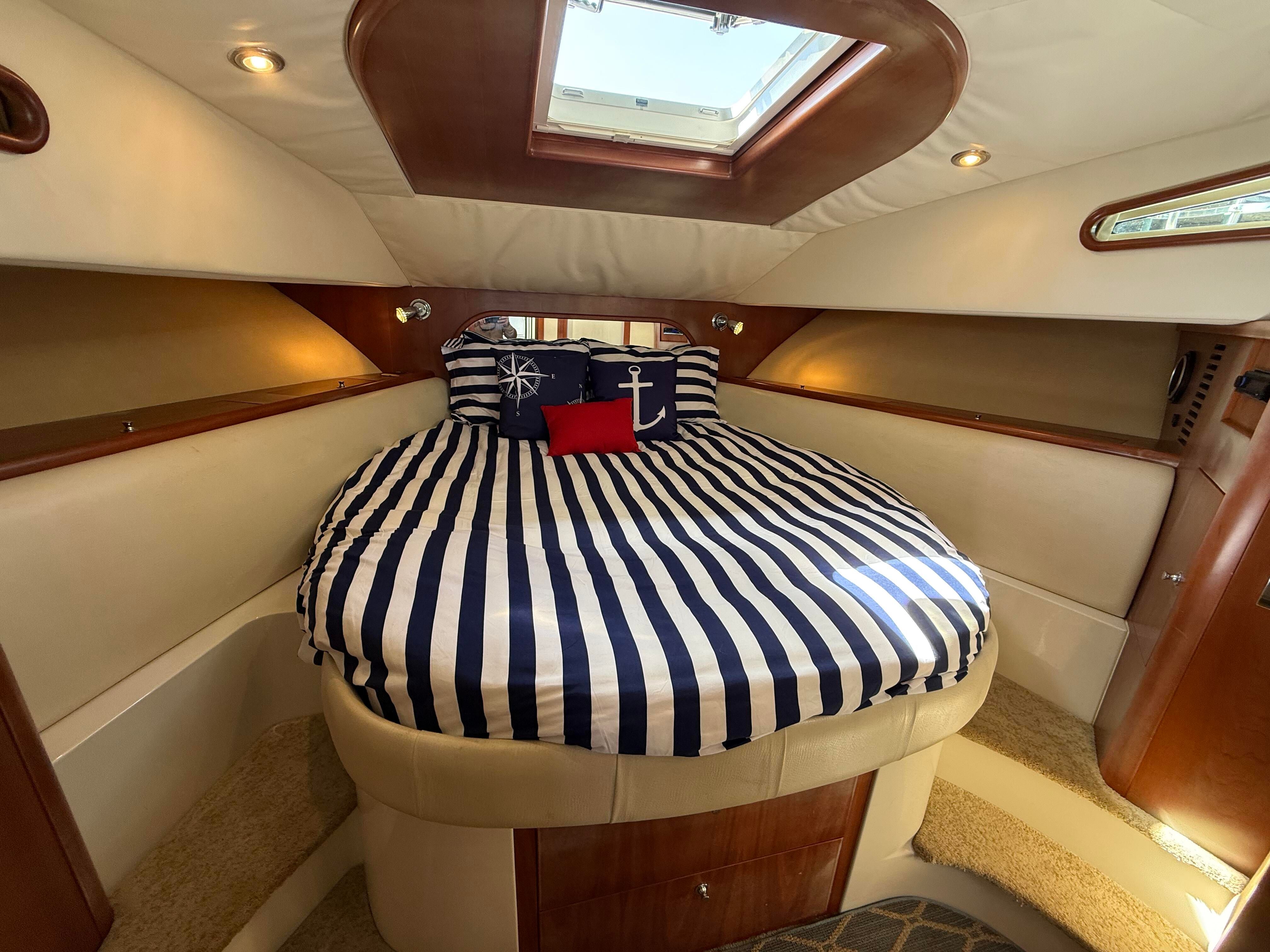 Cabin of the 2007 Chris-Craft Roamer 40 with striped bedding and nautical-themed pillows.