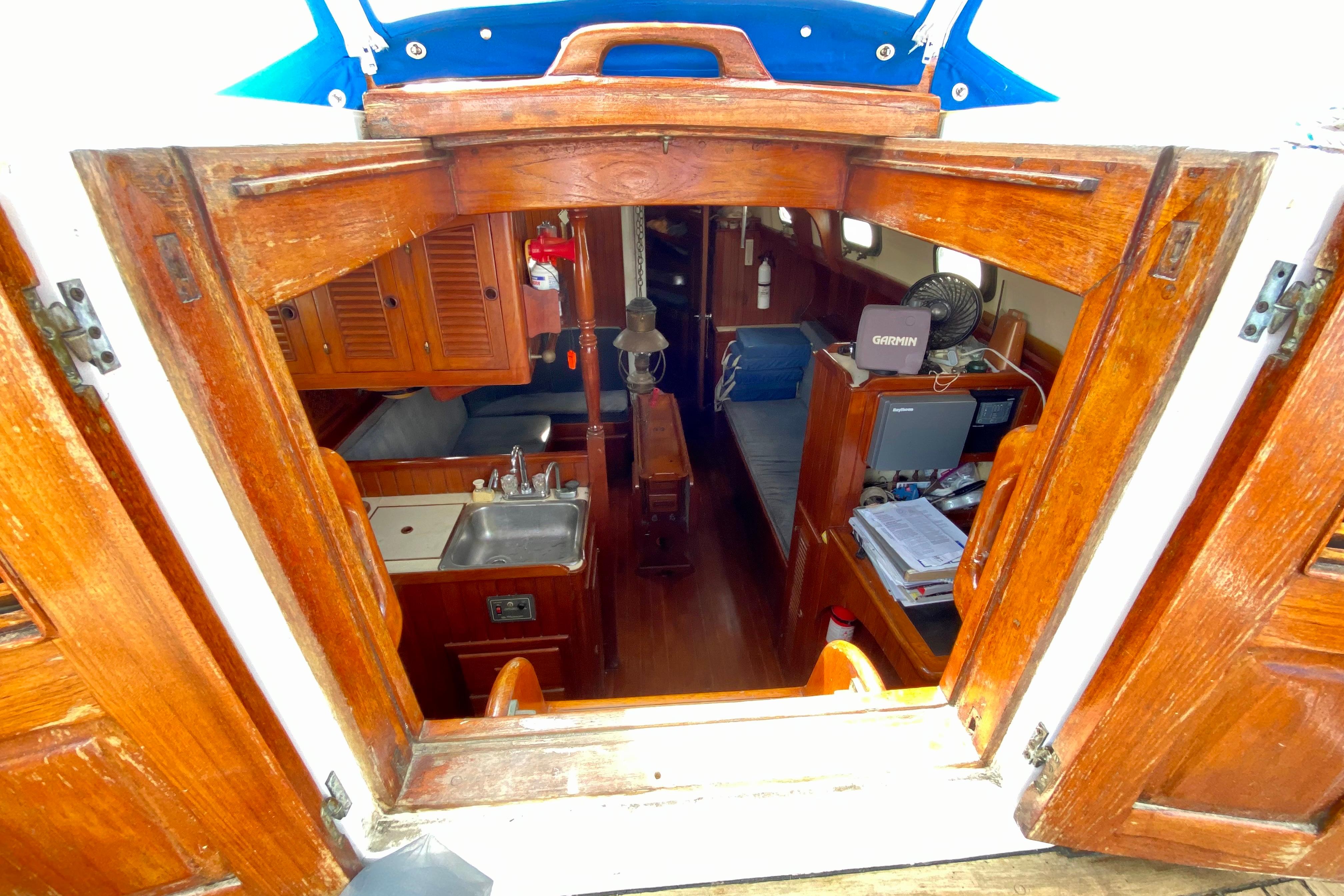 Interior view of 1981 Union EO 32 sailboat, featuring wooden cabinetry and compact living space.