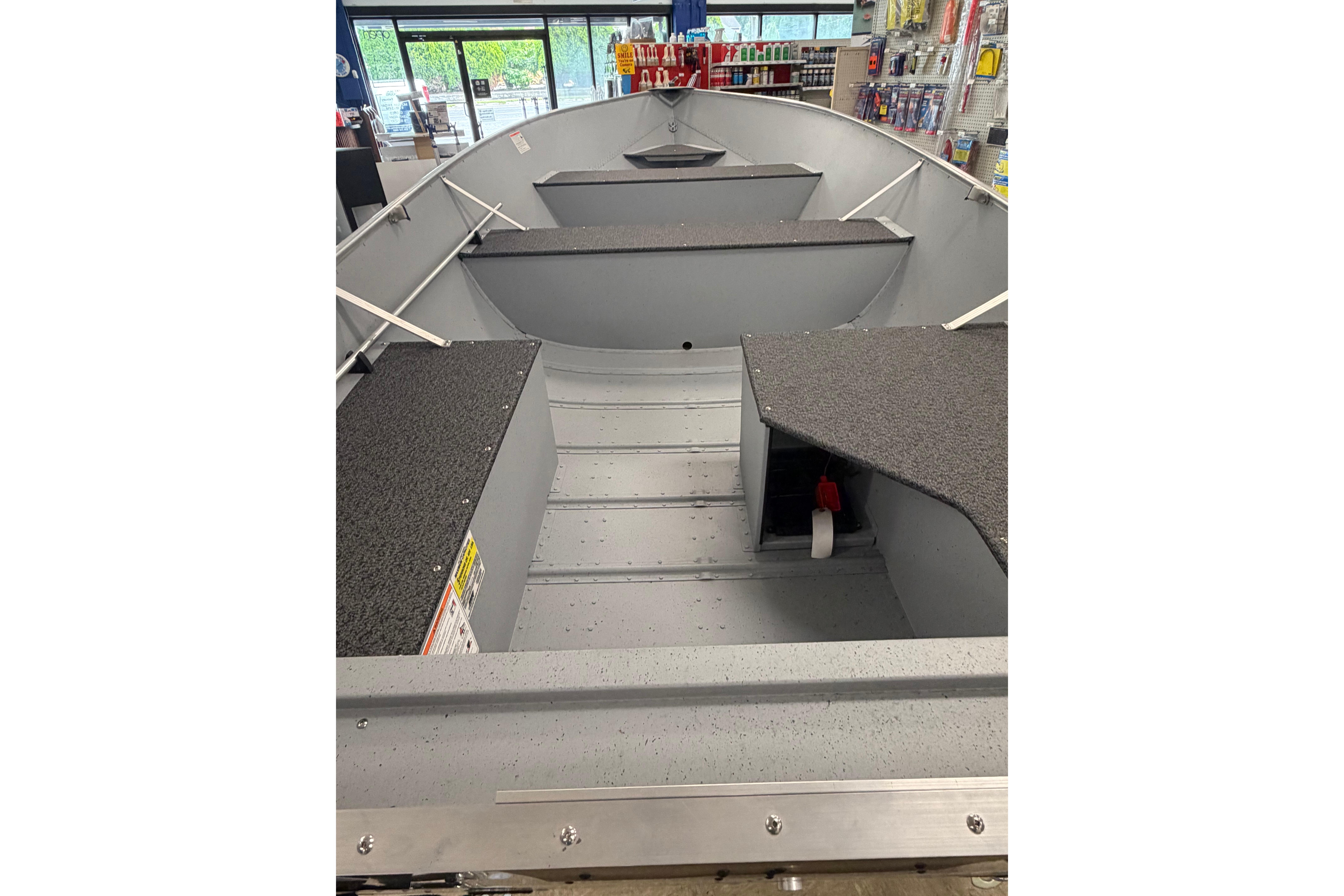 2027 Lund WC 16 boat interior with storage compartments in a showroom.