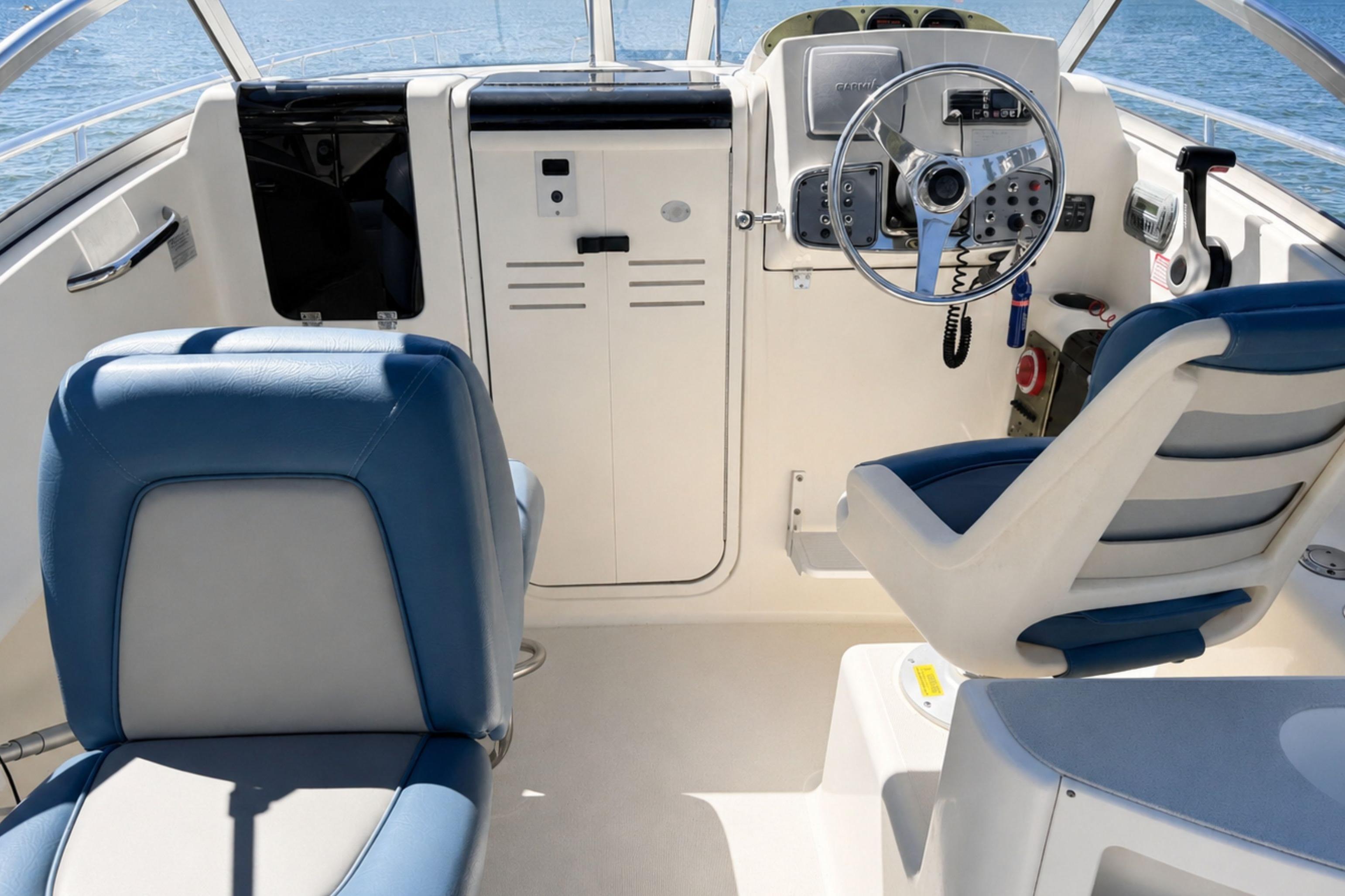 Helm of 2008 Scout 222 Abaco boat with blue and white seating, steering wheel, and controls.