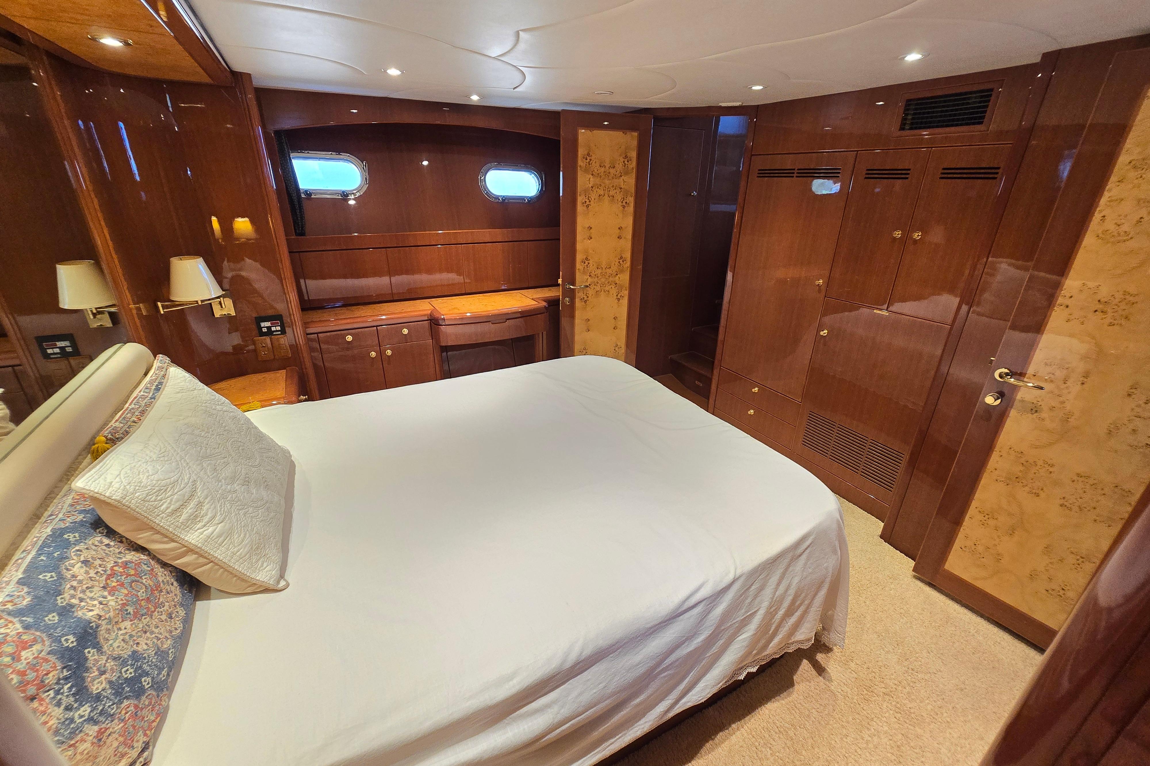 Luxurious 2004 Grand Harbour 58 yacht bedroom with elegant wood finishes and cozy bedding.