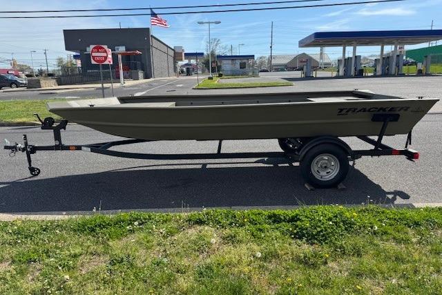 2026 Tracker Grizzly 1860 Utility boat on trailer, parked in urban setting.