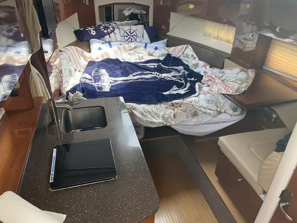 Interior of 2014 Sea Ray 310 Sundancer with bed, sink, and seating area.