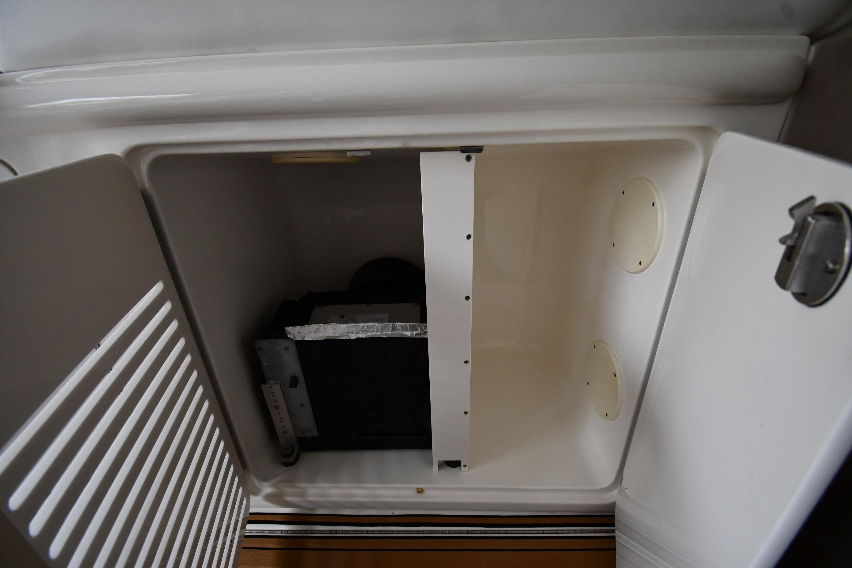 Storage compartment on a 2001 Sea Ray 540 Sundancer boat, open and empty.