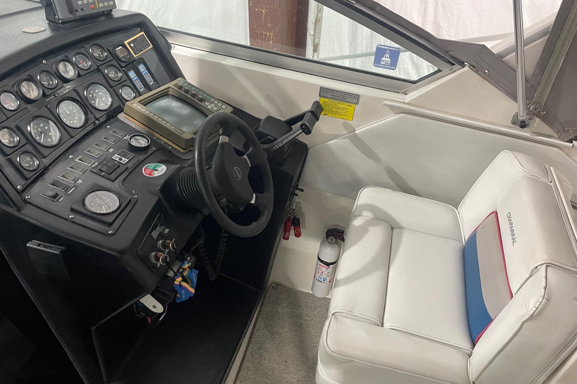 1992 Chaparral Signature 30 boat cockpit with steering wheel, gauges, and white seating.