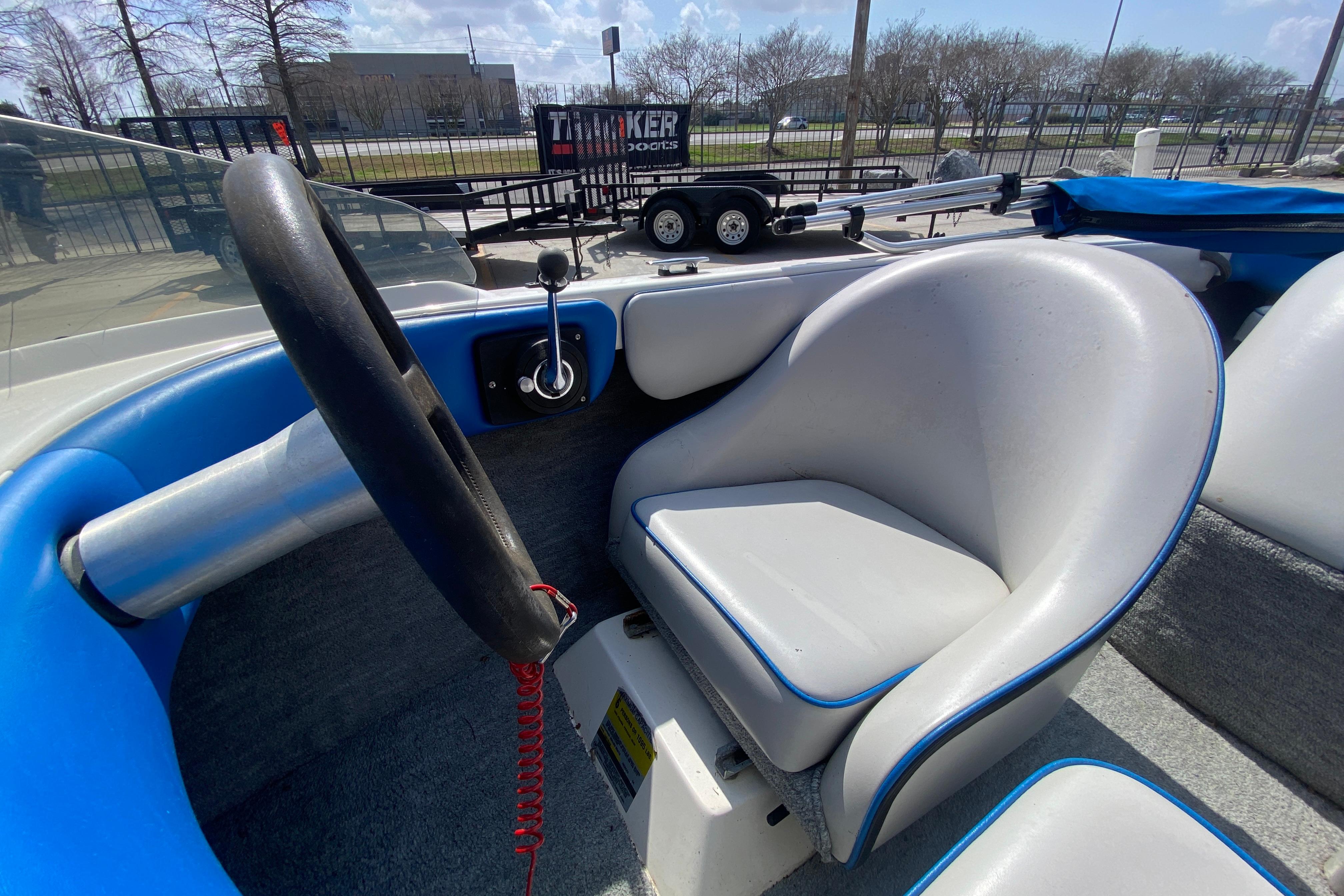 1997 Malibu Tantrum boat interior with steering wheel and seat, parked near a trailer.