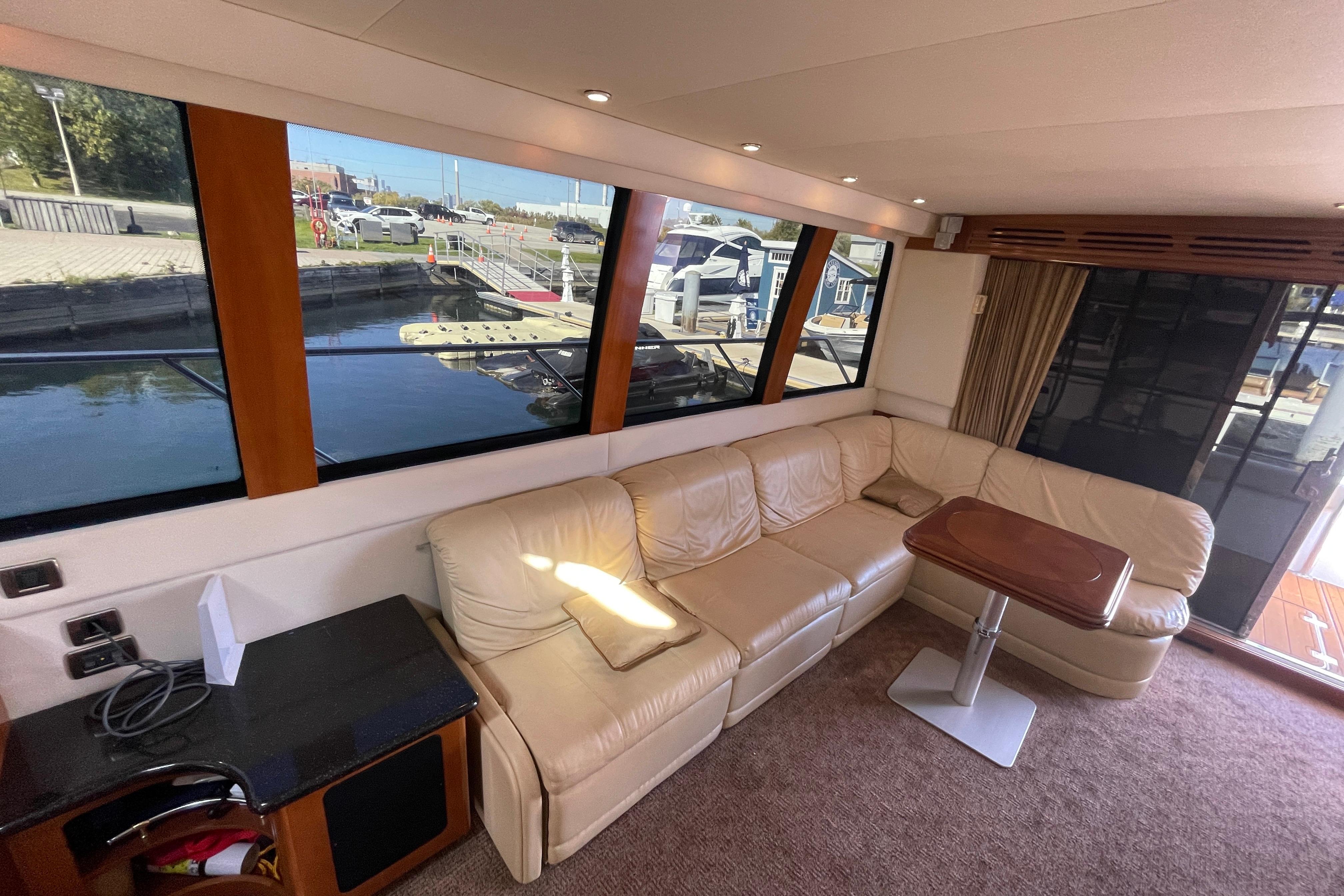 Interior of 2002 Carver 570 Voyager Pilothouse with leather seating and waterfront view.