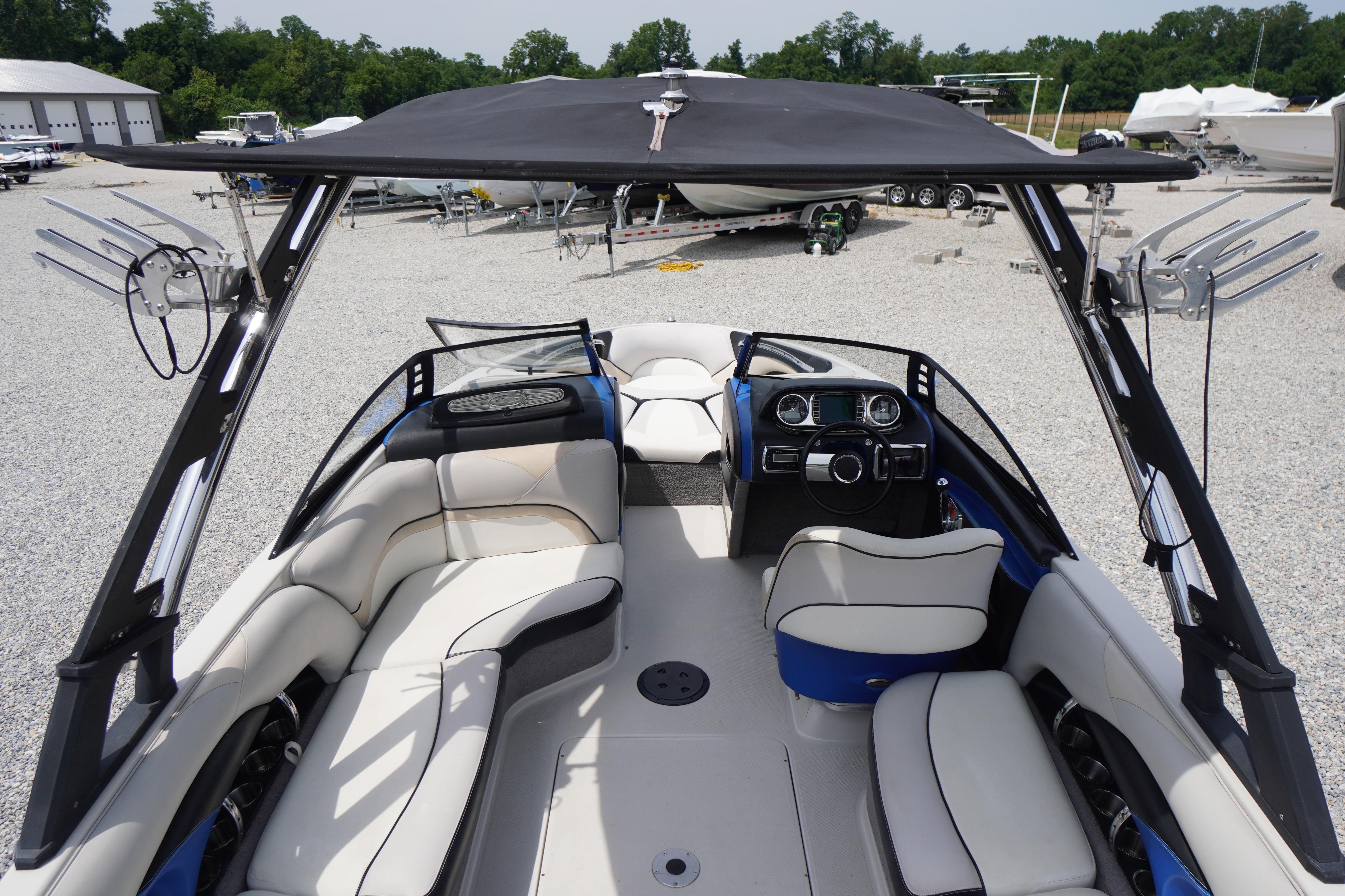 2011 Malibu Wakesetter 21 VLX boat interior with seating and steering wheel, parked outdoors.