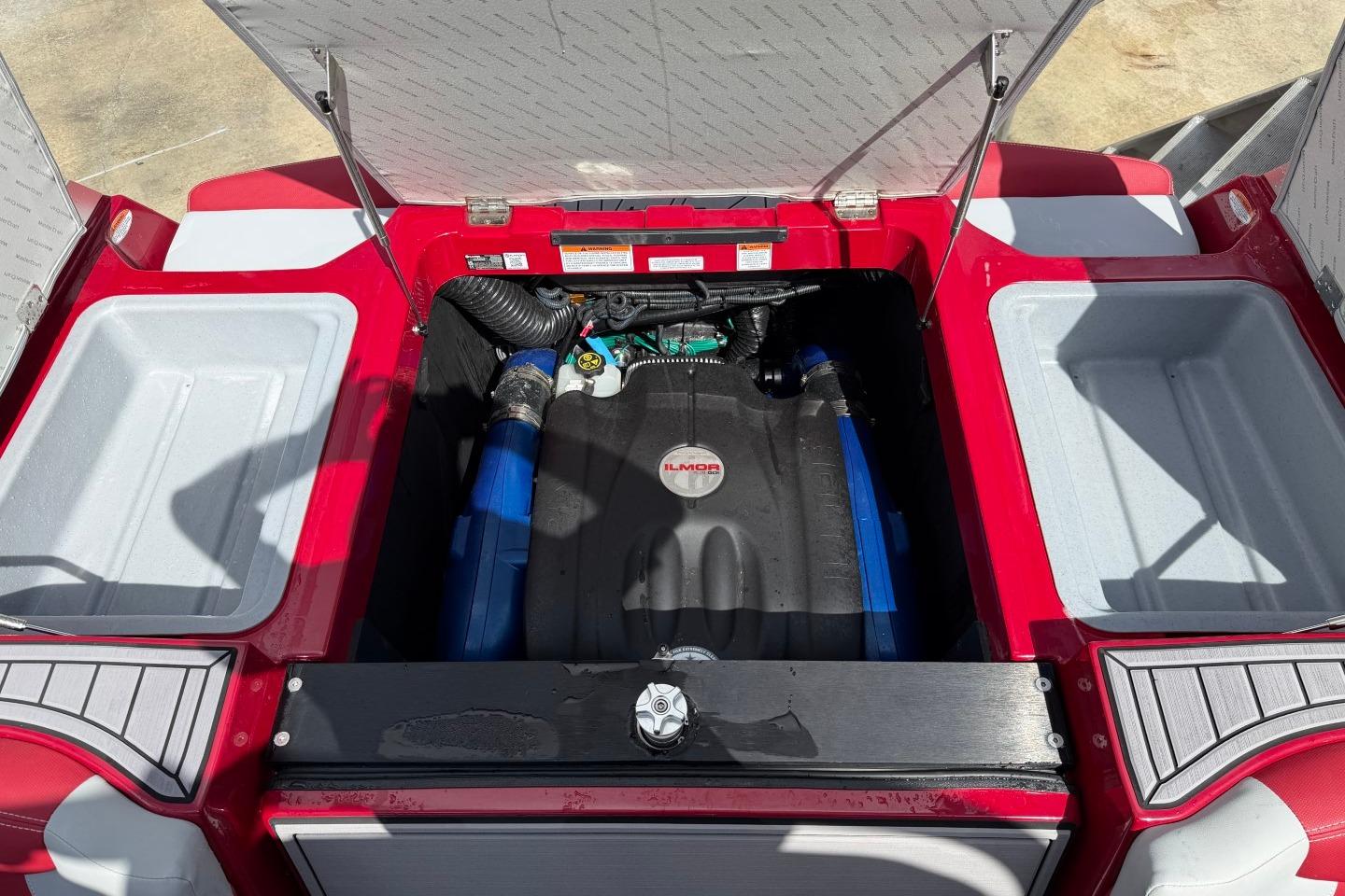 2023 MasterCraft X24 boat engine compartment with Ilmor engine, red and white interior.
