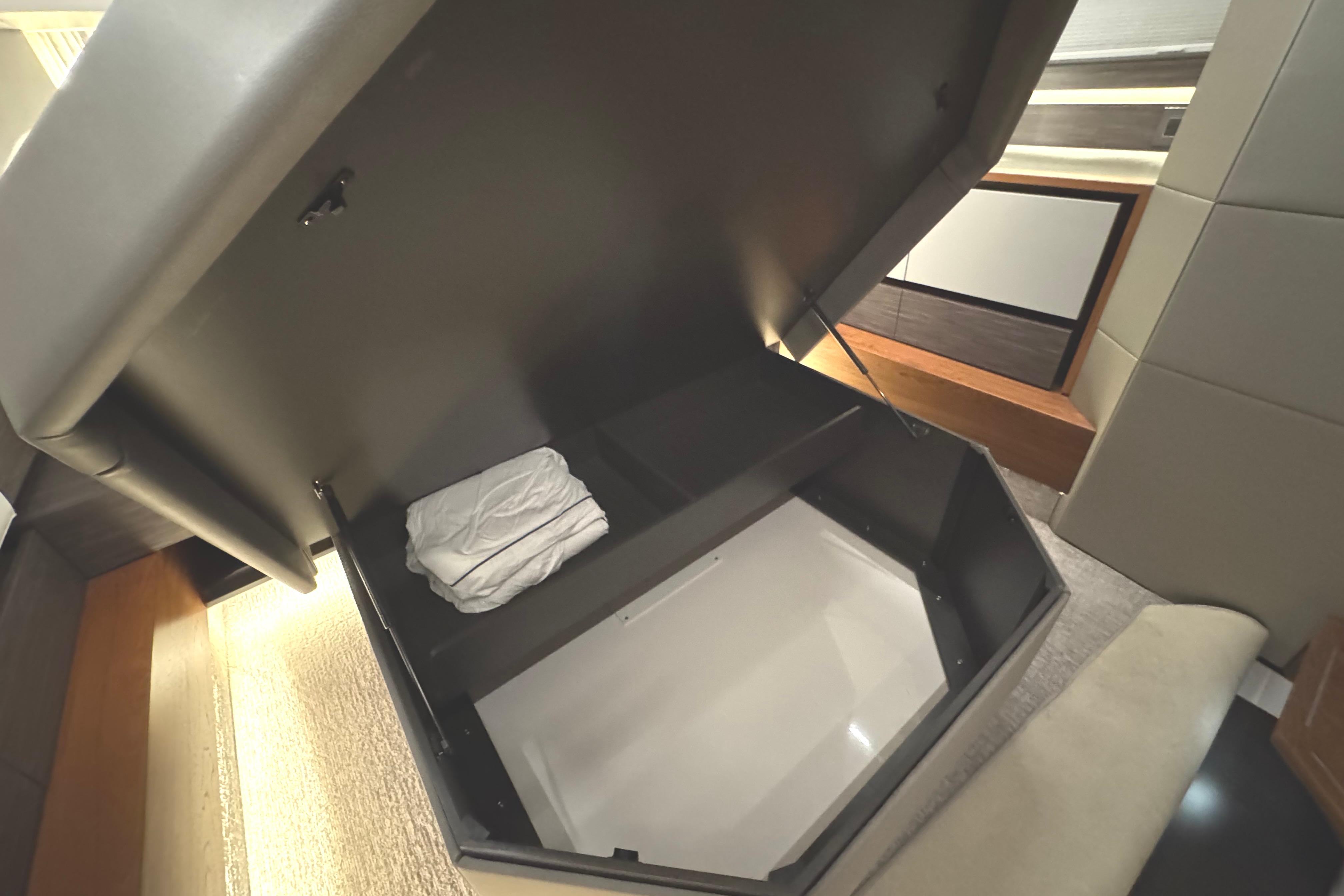 2020 Tiara Yachts C49 Coupe interior storage compartment with folded linens.