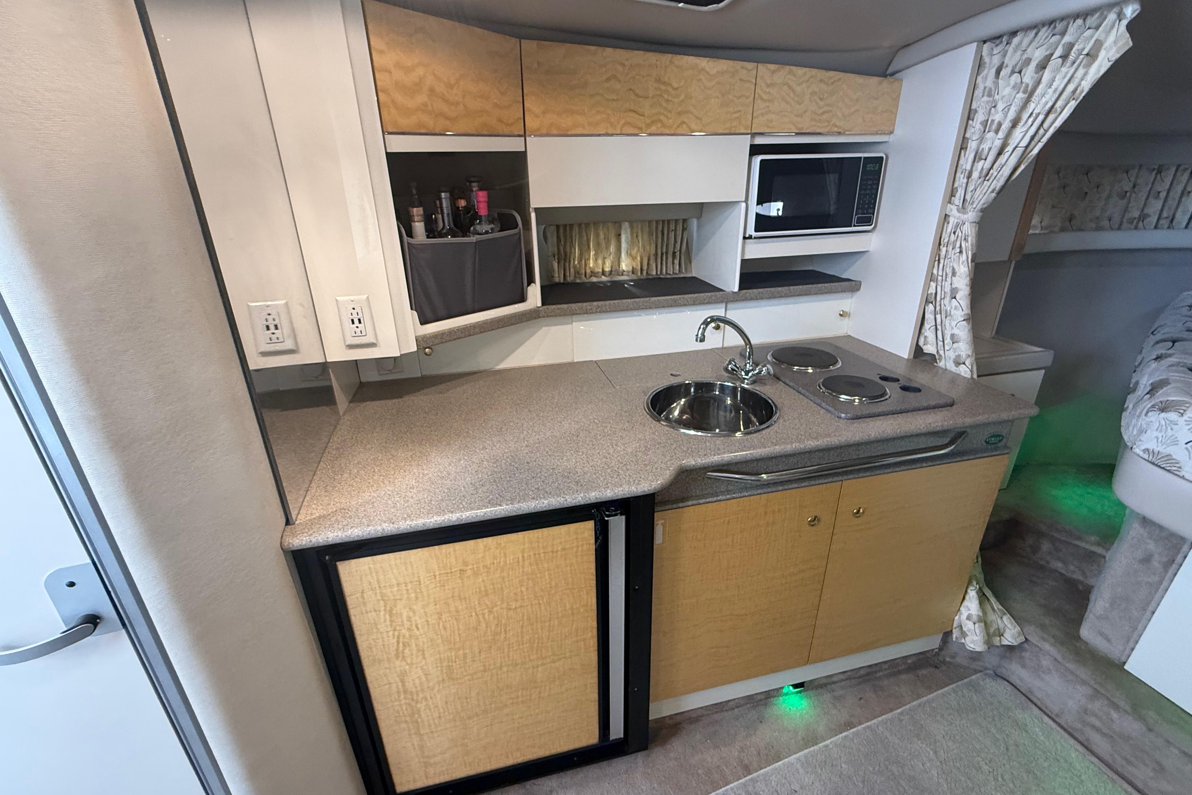 1999 Formula 34 Performance Cruiser kitchen with sink, stove, microwave, and storage cabinets.