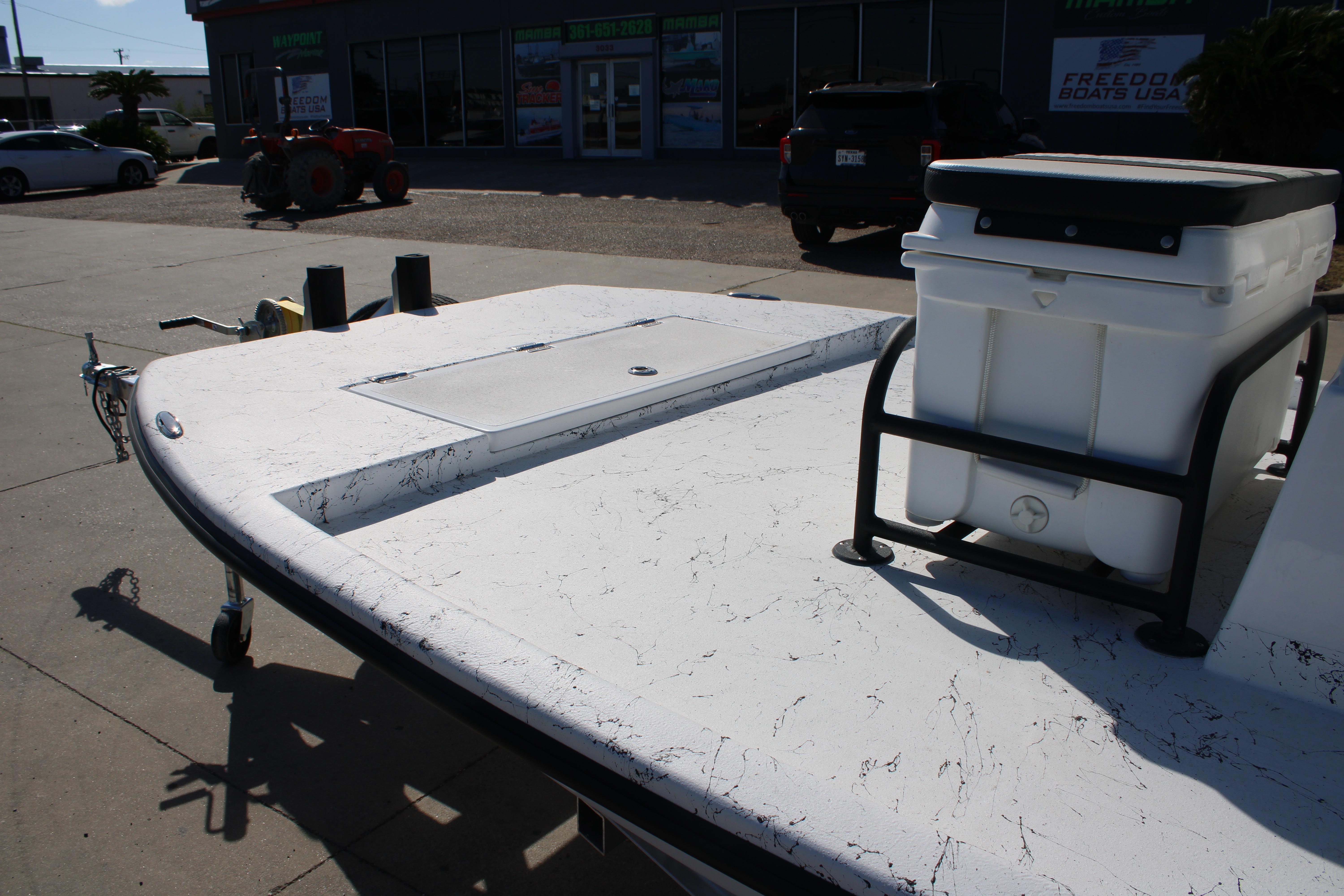 2026 Freedom Boats Chiquita on trailer, featuring a spacious deck and cooler storage.