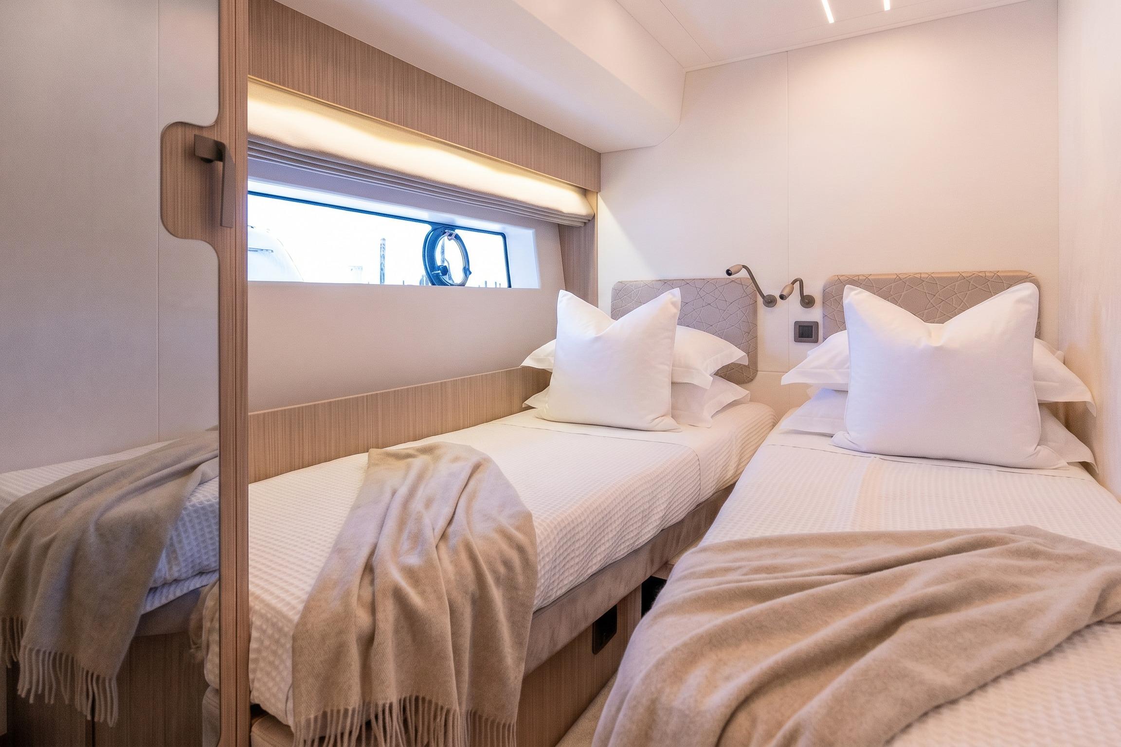 Luxurious twin cabin in 2026 Prestige F5.7 yacht with elegant bedding and modern lighting.