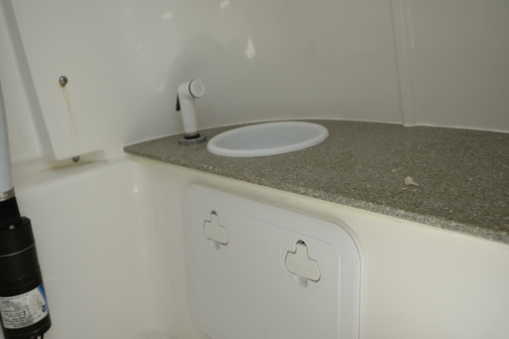 Interior of 2023 Sea Pro 239 Deep V CC boat with sink and storage.