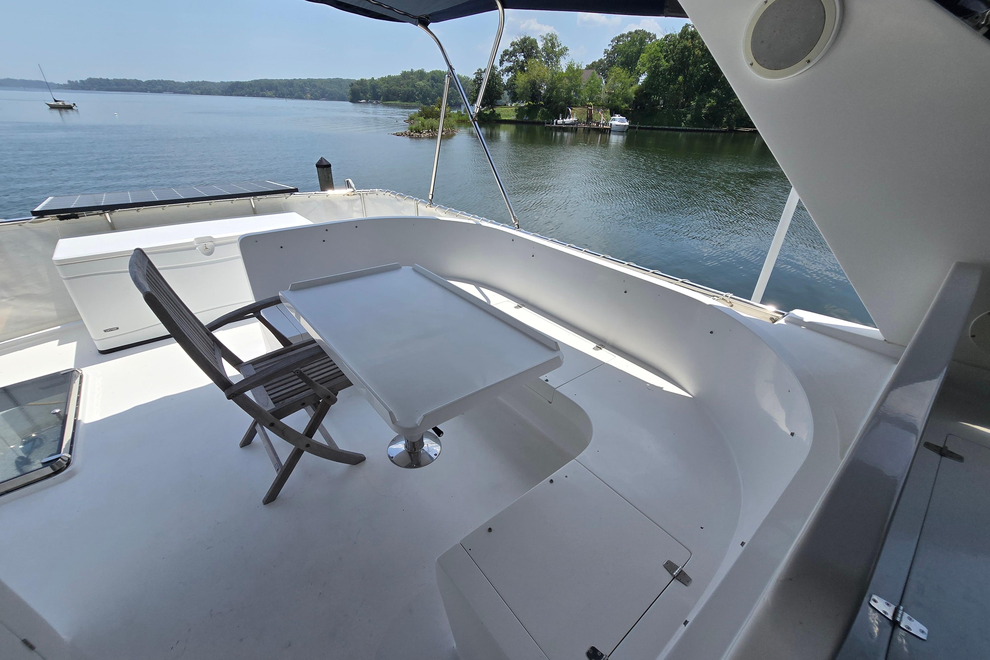 Outdoor seating area on a 2004 Grand Harbour 58 yacht overlooking serene waters.
