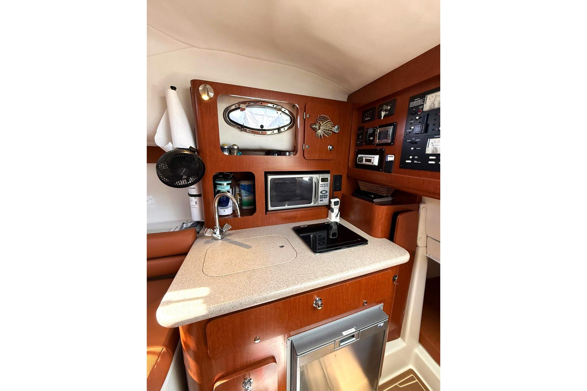 2006 Pro-Line 32 Express boat interior with kitchenette, featuring microwave and control panel.