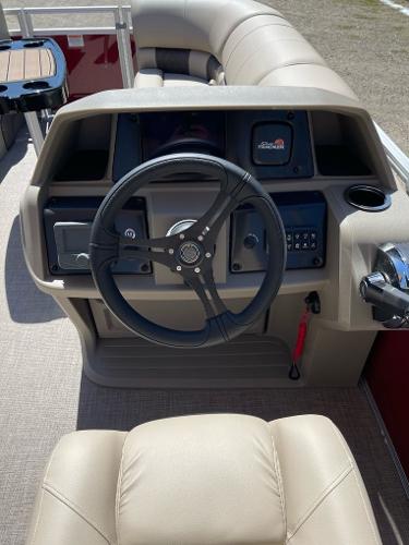 2025 Sun Tracker Party Barge 22 RF DLX steering console with beige seating and controls.