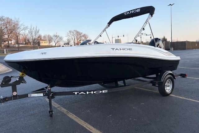 2026 Tahoe T16 boat on trailer in parking lot, featuring sleek design and black hull.
