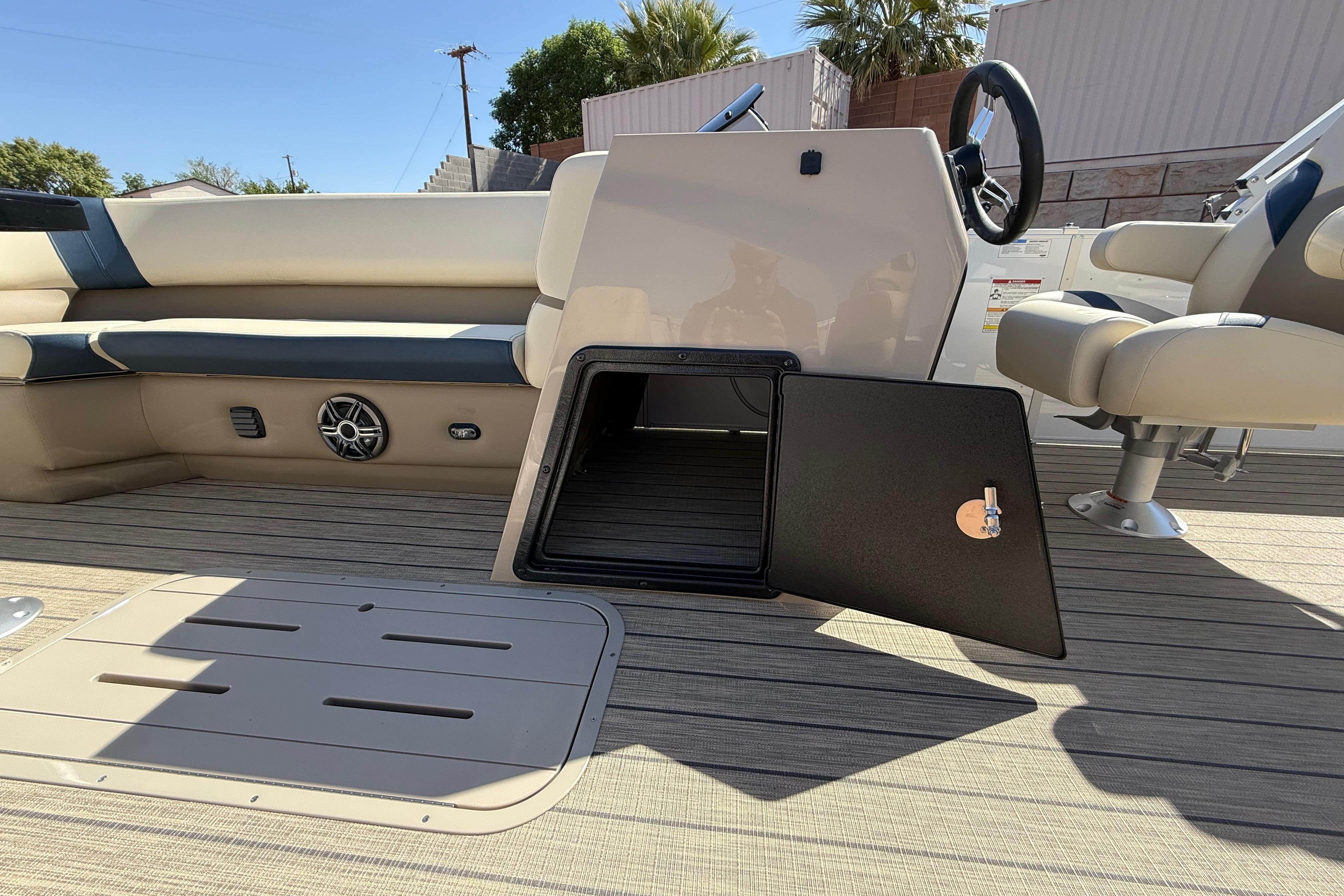 2026 SunCatcher Select 322SL boat interior with open storage compartment and seating.