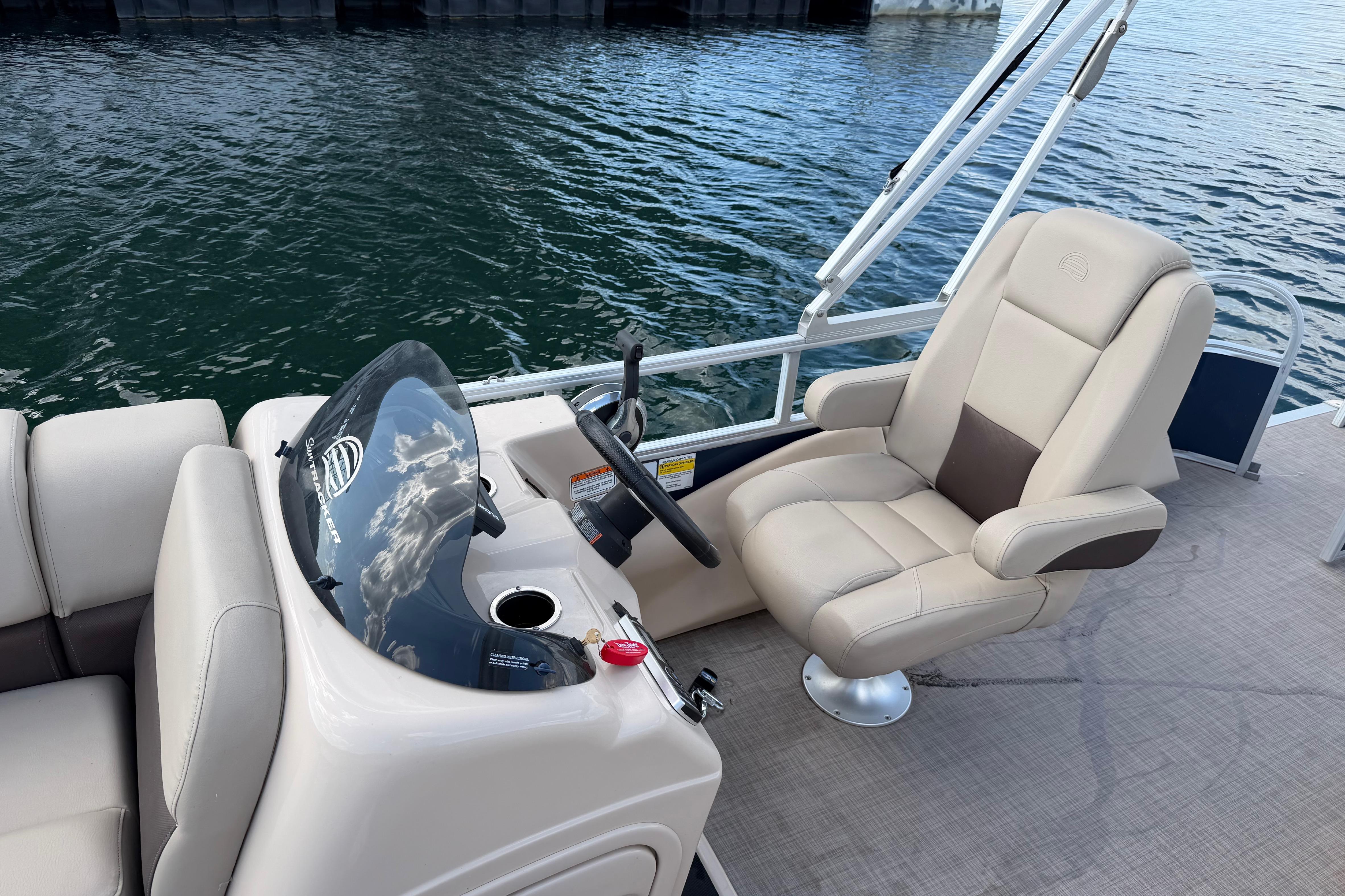 2019 Sun Tracker Party Barge 22 Sport Fish boat interior with captain's chair and steering console.
