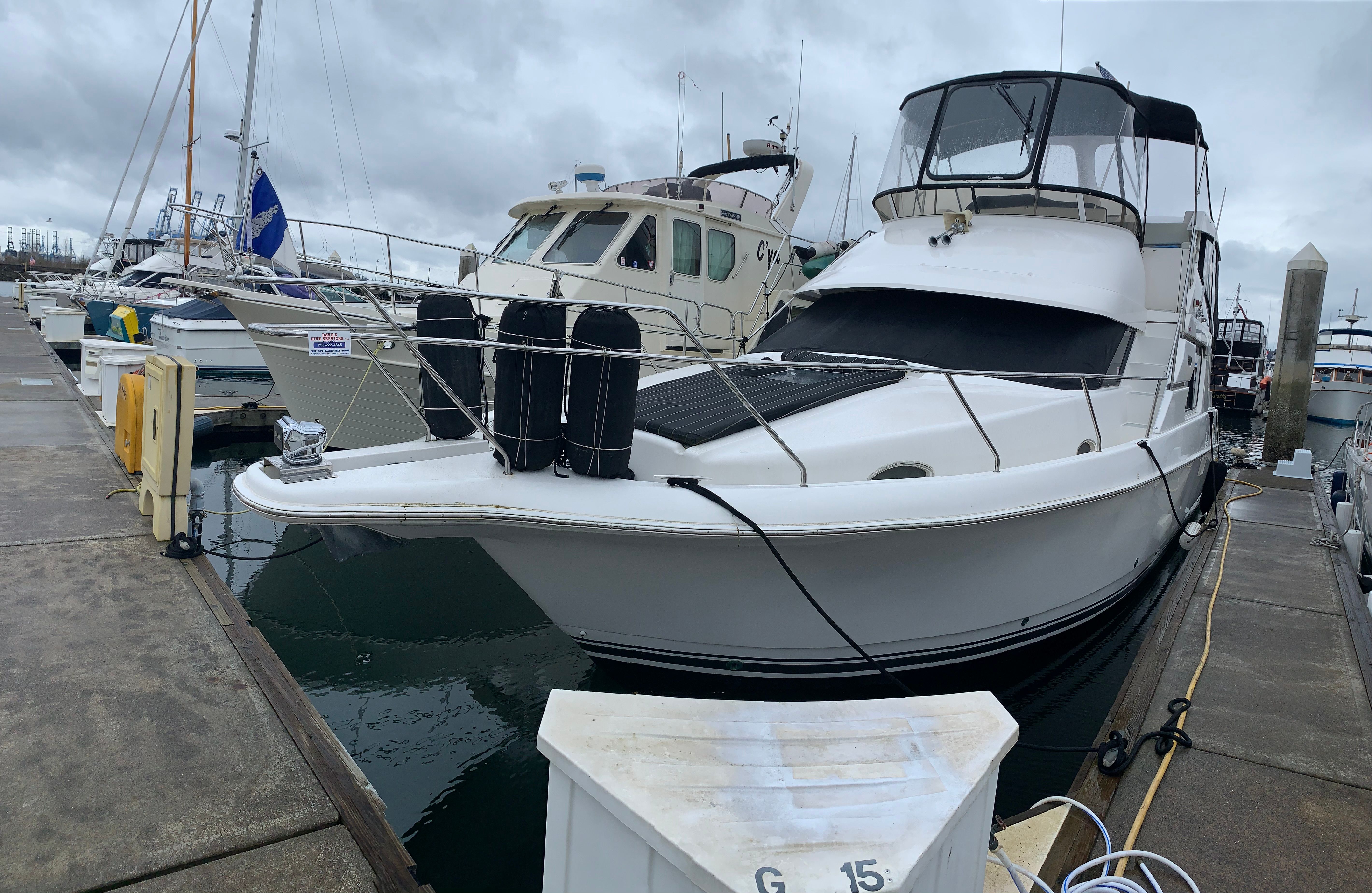 1998 Silverton 372/392 yacht docked in harbor under cloudy skies.