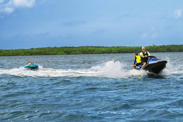 Manufacturer Provided Image: 2026 Sea-Doo Spark for 2 towing a person on a tube across a scenic lake.