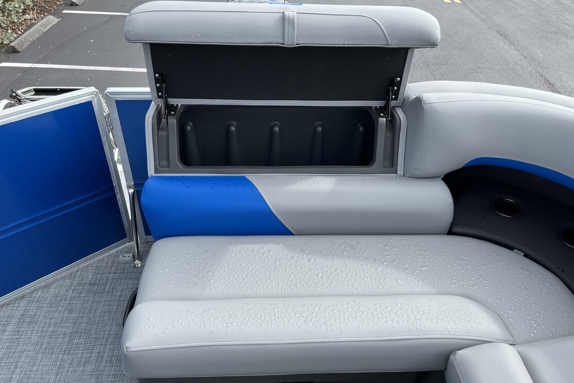 2026 Sun Tracker Party Barge 20 DLX with open storage compartment and wet seating.