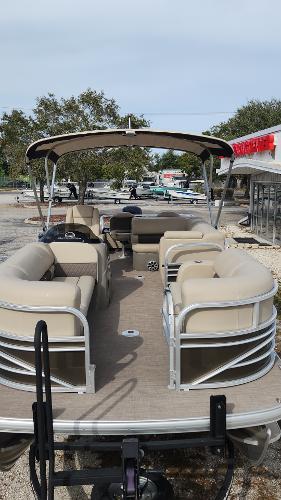 2023 Sun Tracker SportFish 22 DLX pontoon boat with beige seating and canopy.