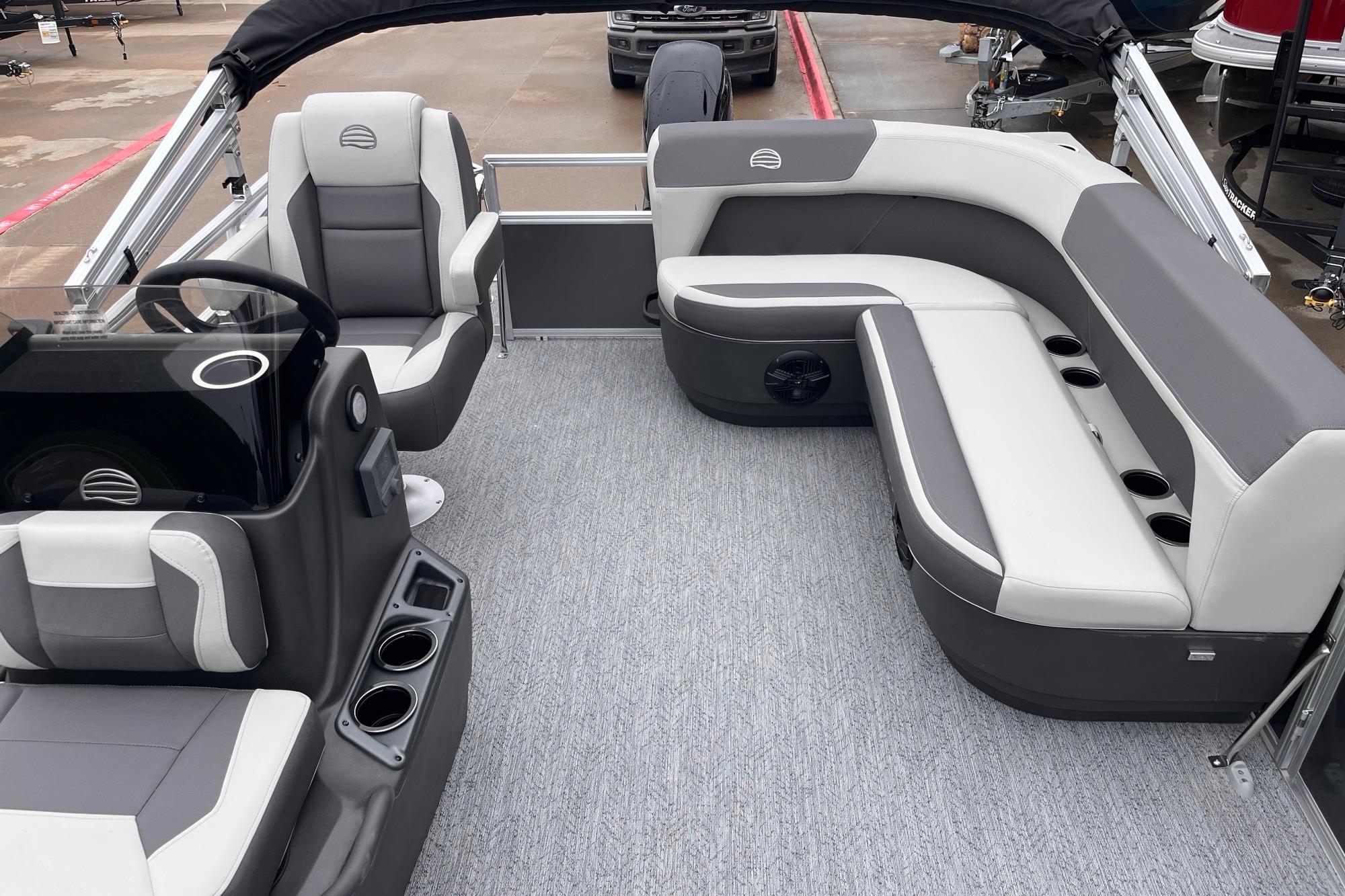 2026 Sun Tracker Bass Buggy 16 XL Select interior with gray and white seating, cup holders, and steering console.
