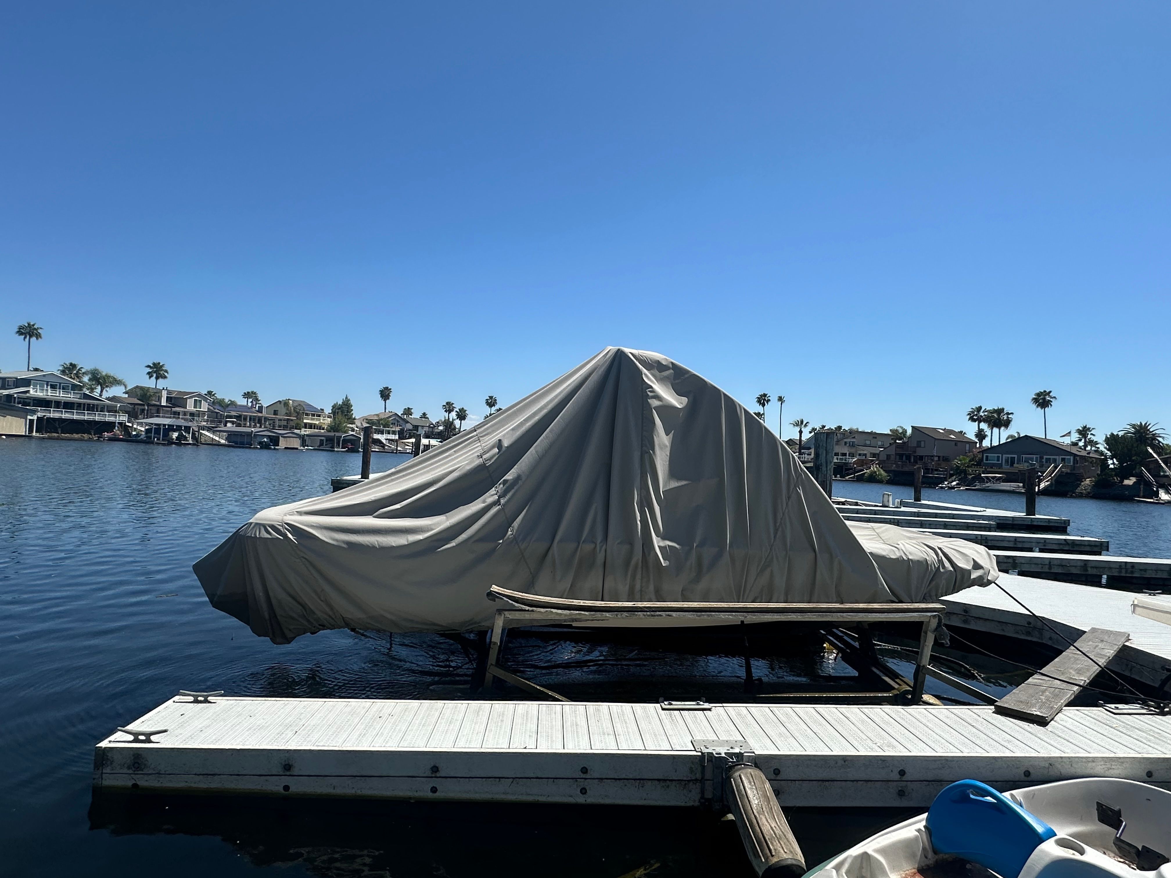 Covered 1998 Correct Craft Air Nautique boat on a dock.