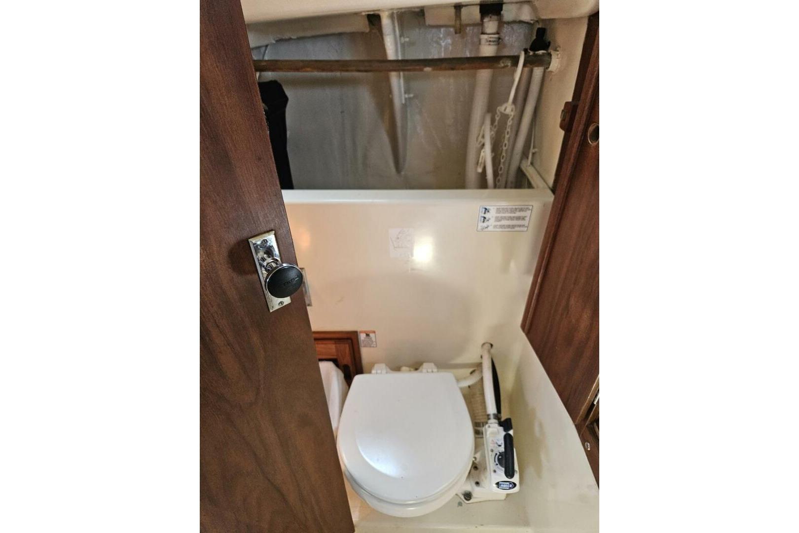 1977 Pearson 30 sailboat bathroom with toilet and wooden door.