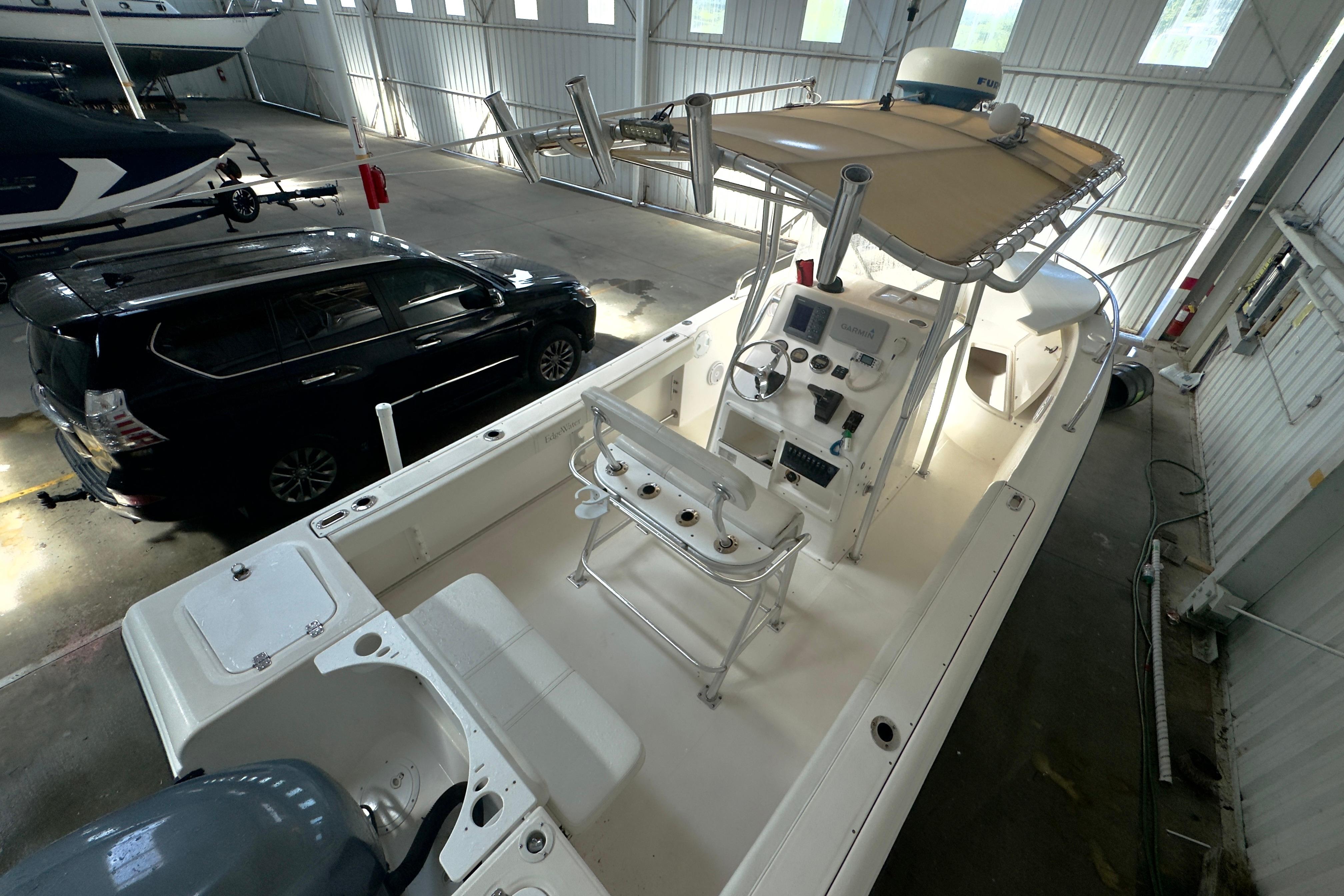 2001 Edgewater 225CC boat in indoor storage, featuring a center console and canopy.