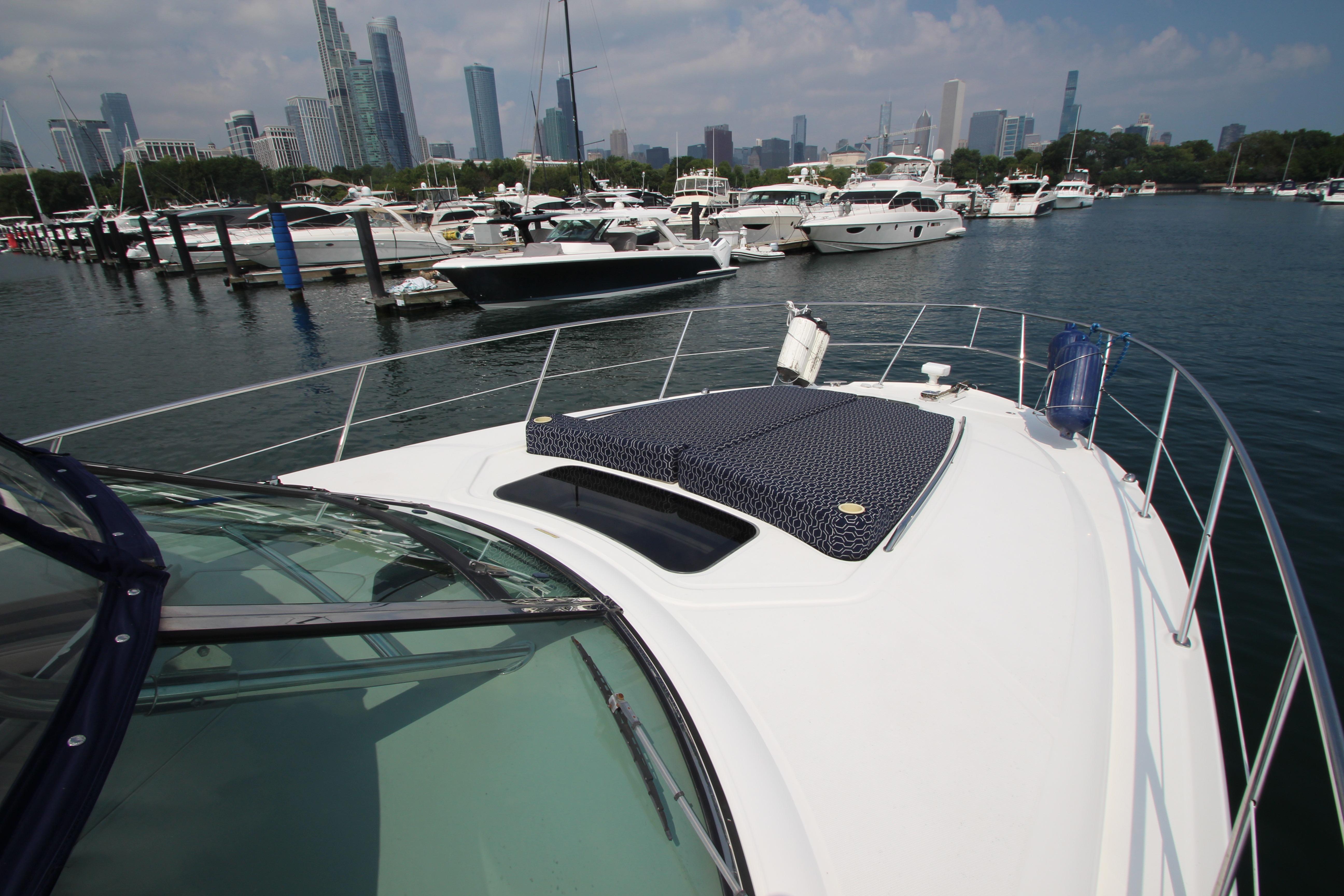 2004 Sea Ray 40 Sundancer yacht docked in marina with city skyline in background.