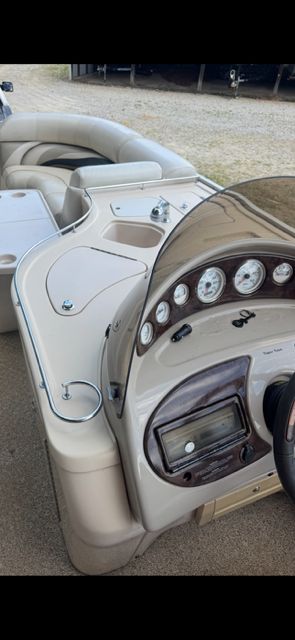 The image shows a boat's cockpit with a sleek dashboard and beige seating.