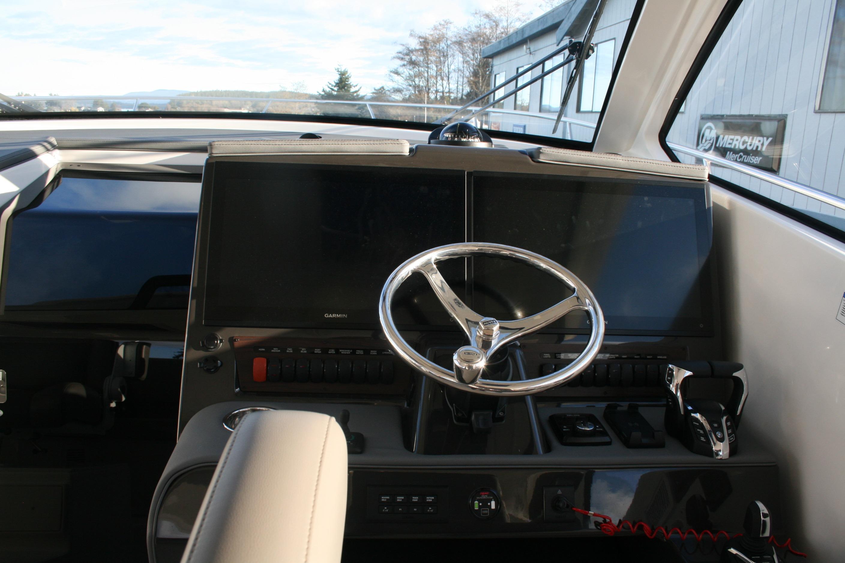 Helm of 2025 Pursuit OS 405 Offshore boat with modern controls and navigation screens.