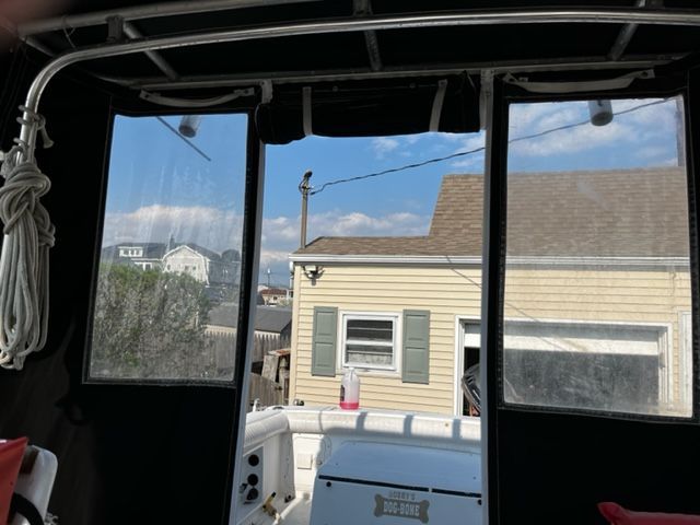 View from inside a Sport-Craft 252 Sport Fish boat, looking out at a house and blue sky.