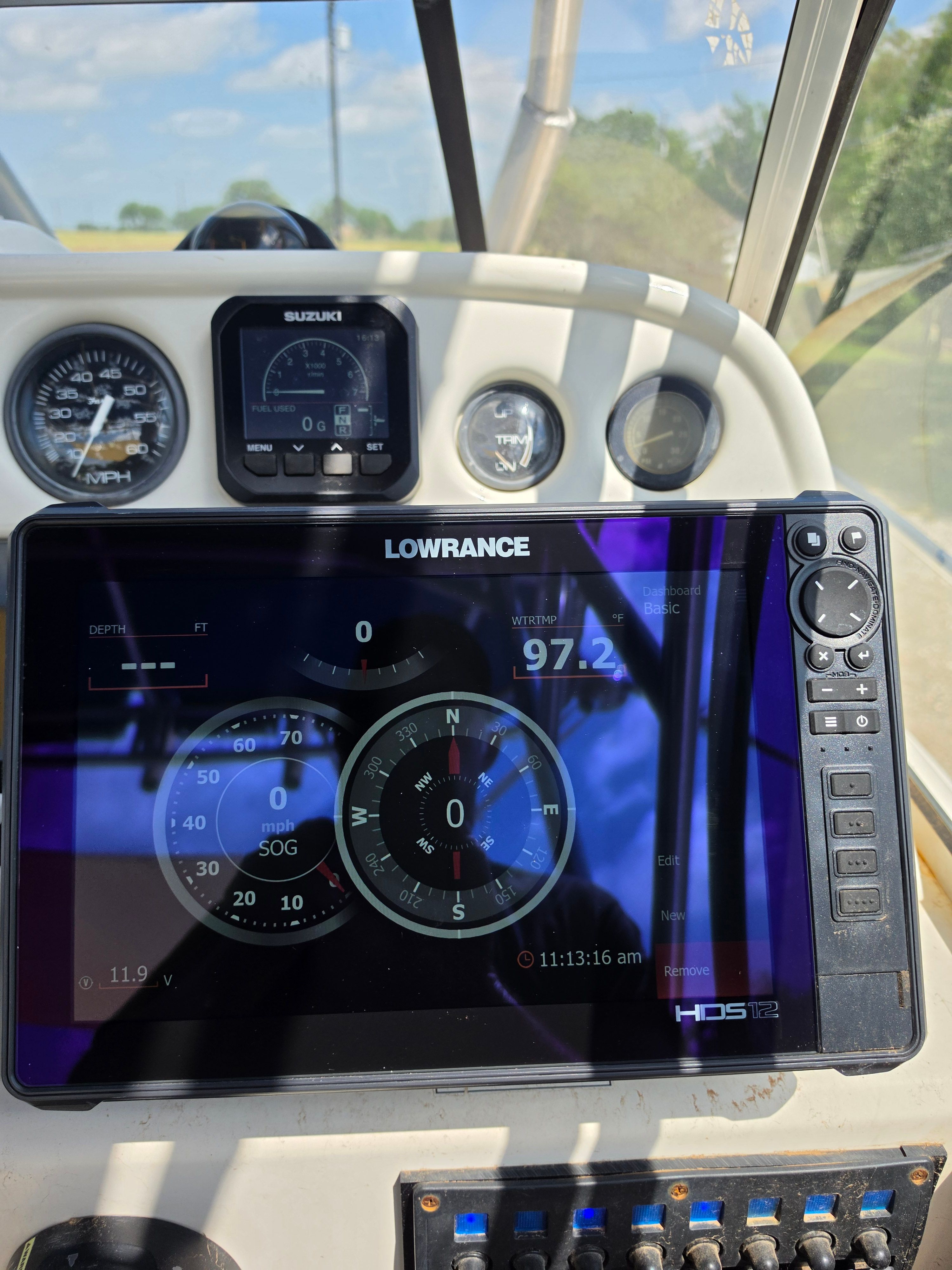 The image shows a boat cockpit with a Lowrance navigation system and various instruments.