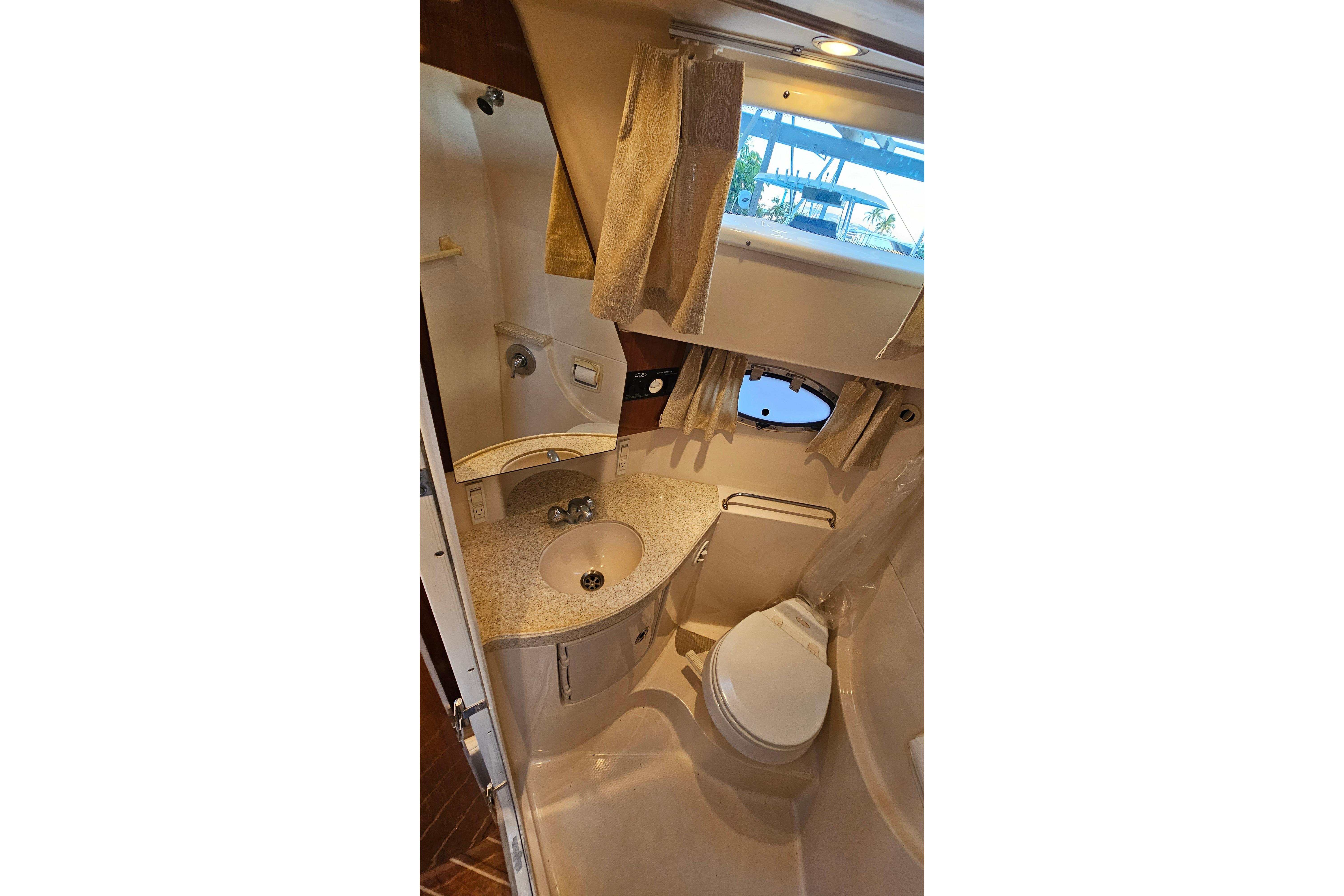 2005 Regal 3060 Window Express yacht bathroom with sink, toilet, and window.