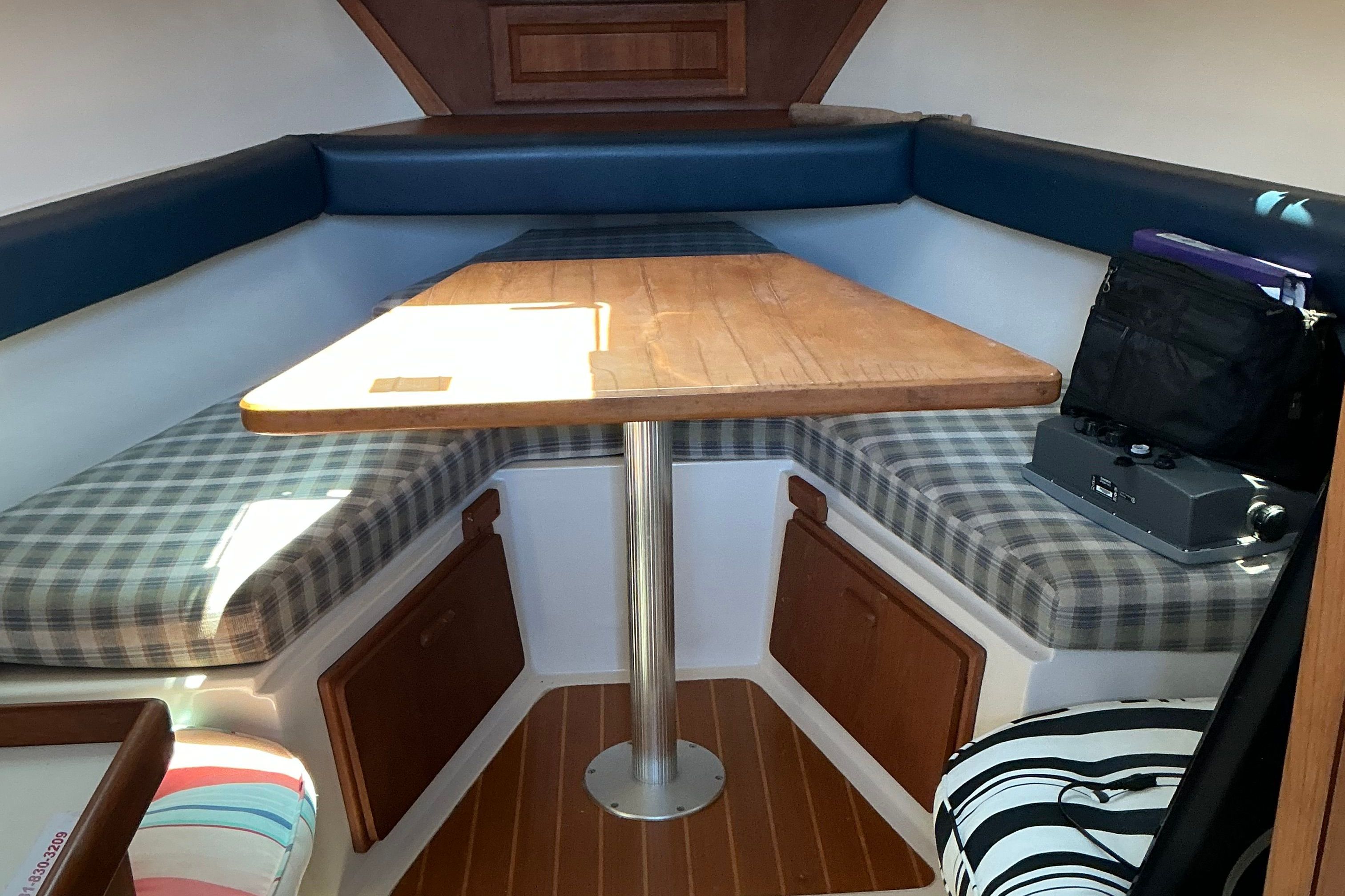 Interior of a 1999 Mainship Pilot 30 with table and seating area.