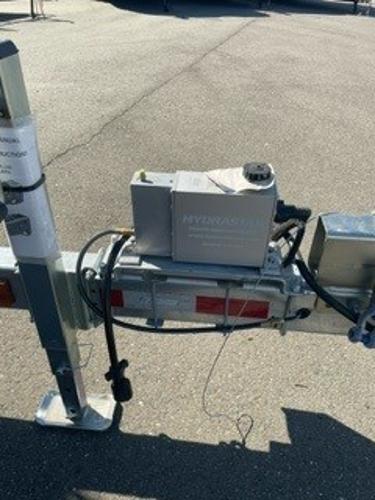 Trailer hitch mechanism of a 2025 Spartan 2600 Olympia on asphalt surface.