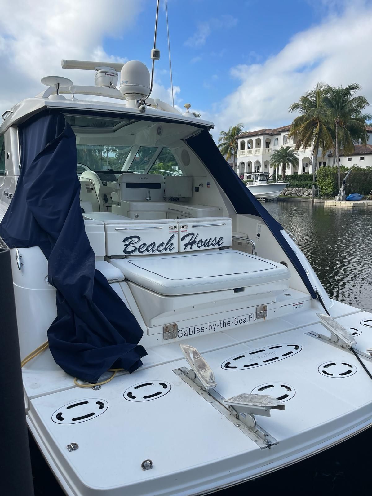 2010 Sea Ray 450 yacht named 'Beach House' docked by the water.