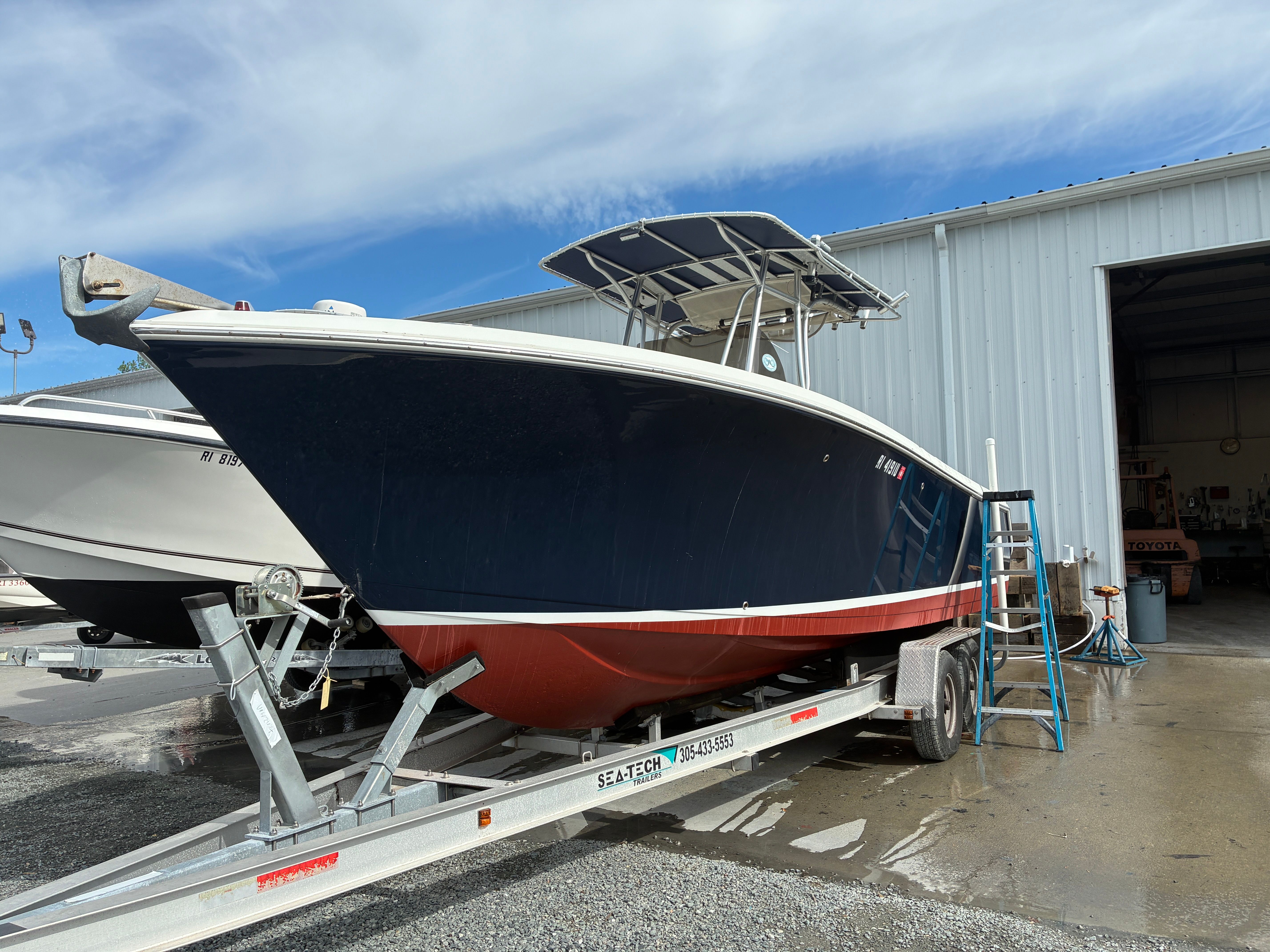 2007 Sailfish 2660 boat on trailer outside warehouse.