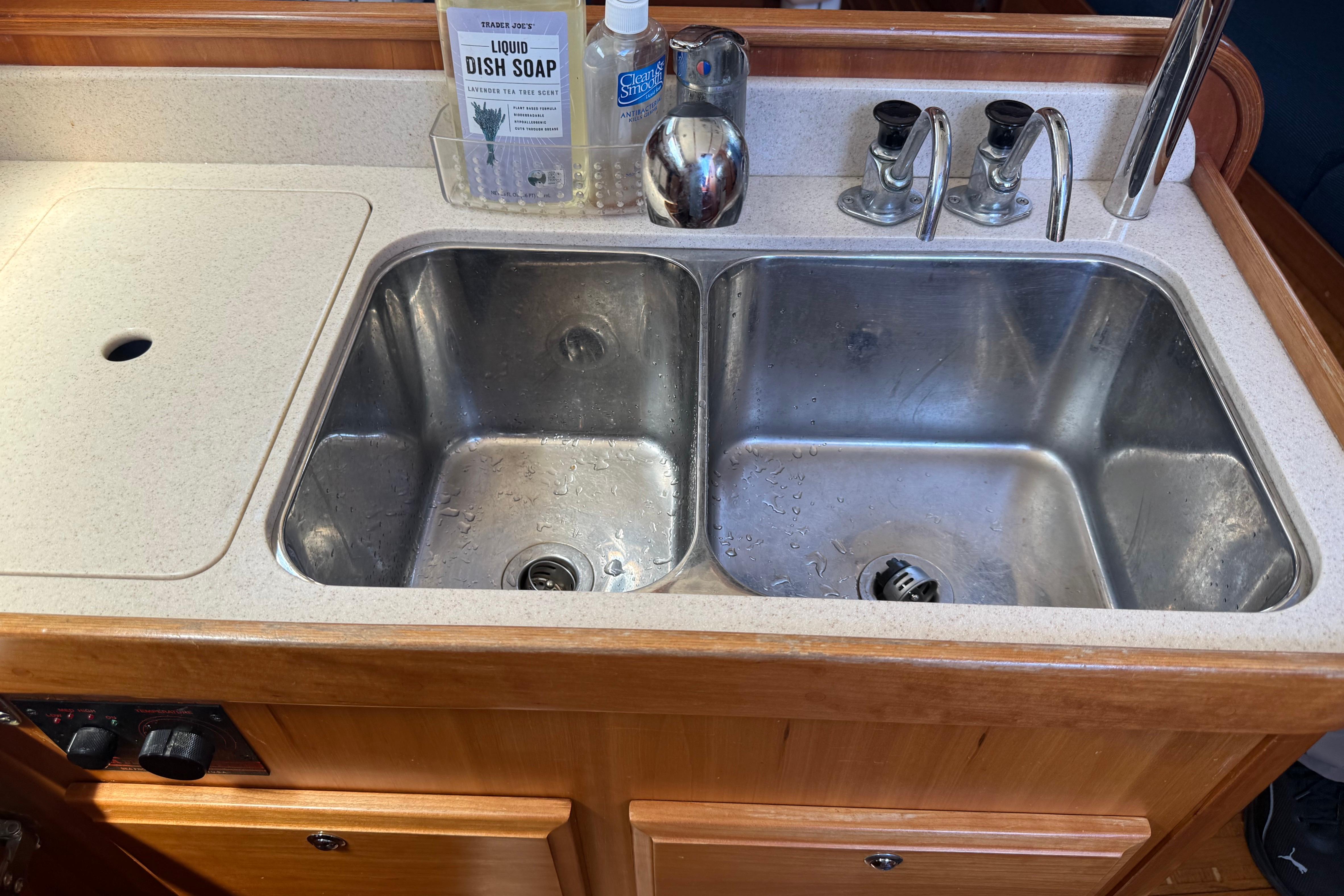 Double stainless steel sink in a 2004 Sabre 386 yacht galley with dish soap.