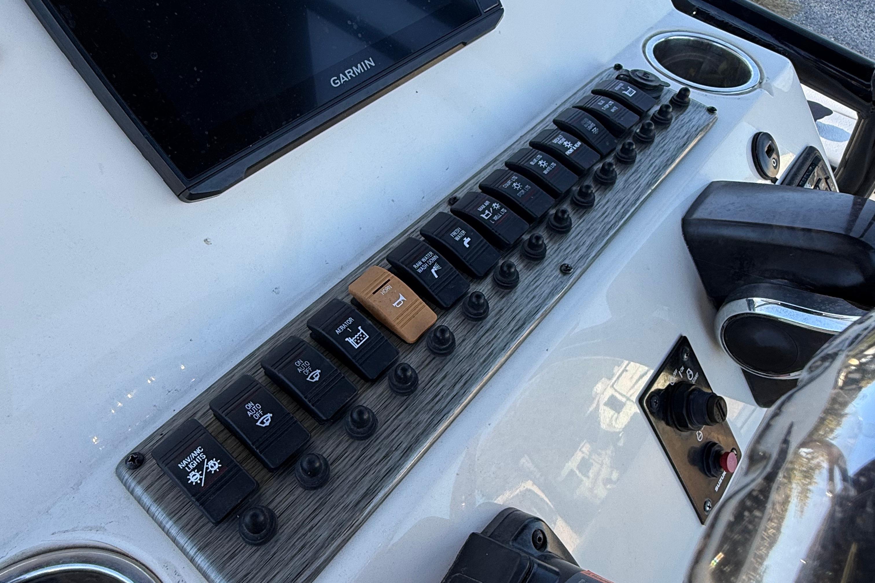 Control panel of 2021 Carolina Skiff 26 Ultra Elite boat with switches and Garmin display.