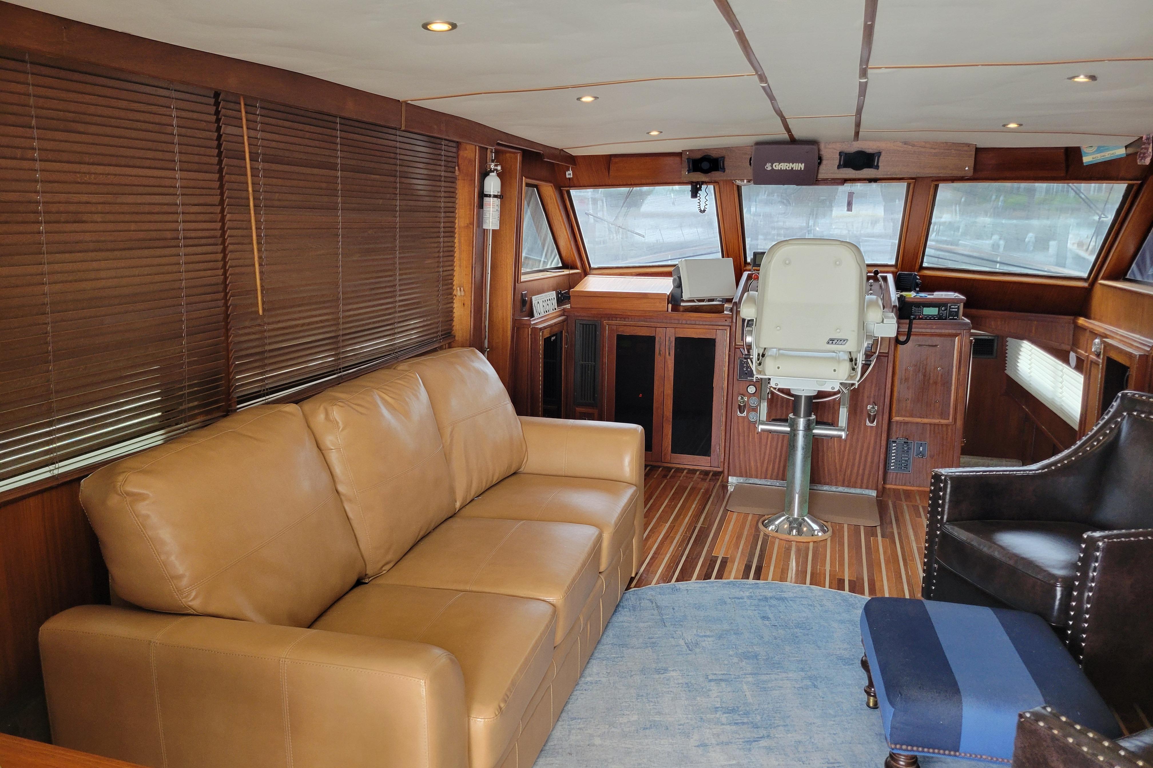Interior of 1980 Hatteras 53 Yacht Fisherman with leather seating and wooden helm.