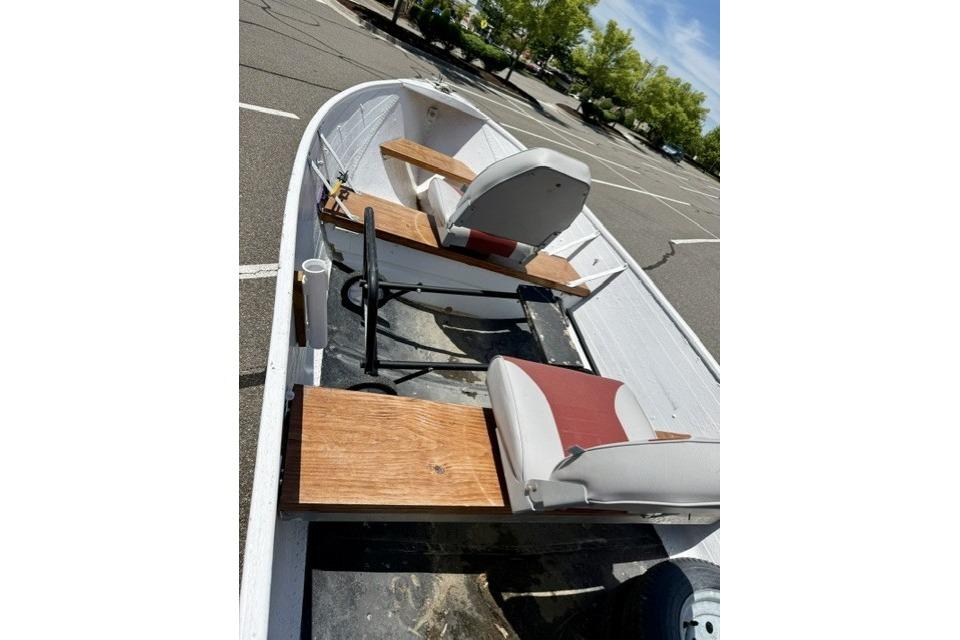 1958 Jon Boat Aluminum model with wooden seats in a parking lot.